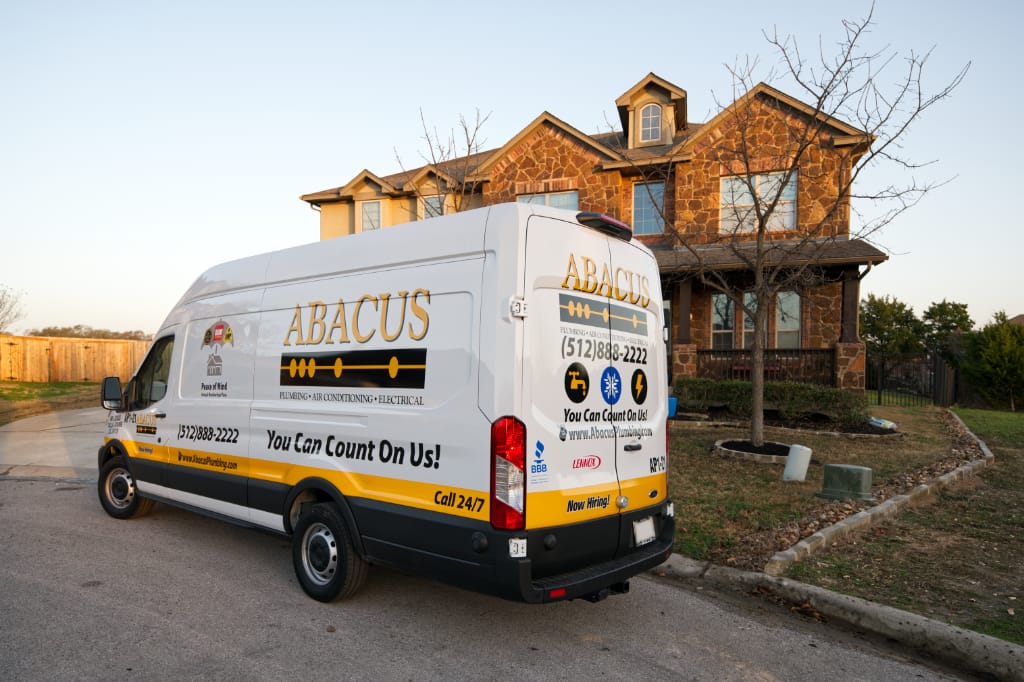 A clean, fully branded service van from Abacus Plumbing, Air Conditioning, & Electrical parked at a customer's home shows dependable, professional service ready when you need it.