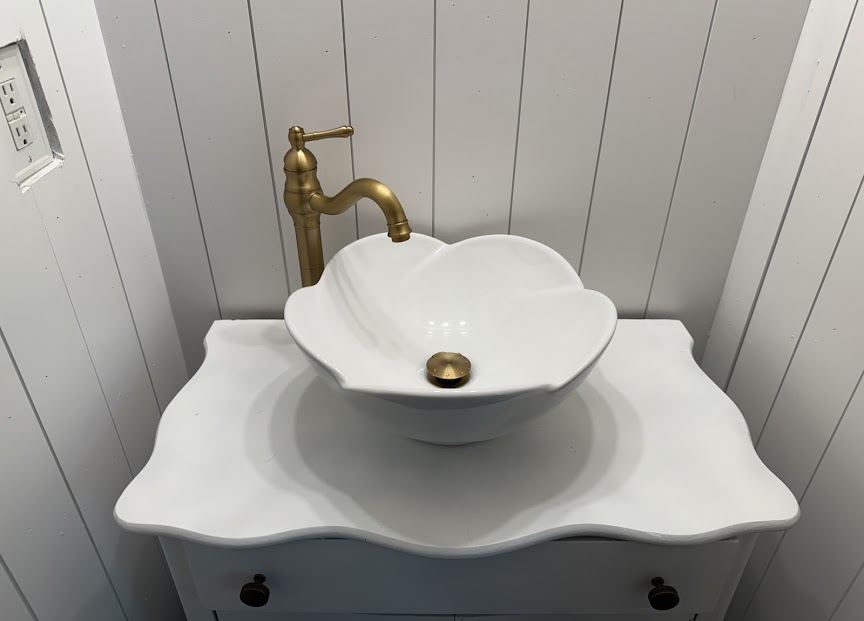 A beautifully installed vessel sink with brass fixtures showcases the careful craftsmanship customers expect from Abacus Plumbing, Air Conditioning, & Electrical.