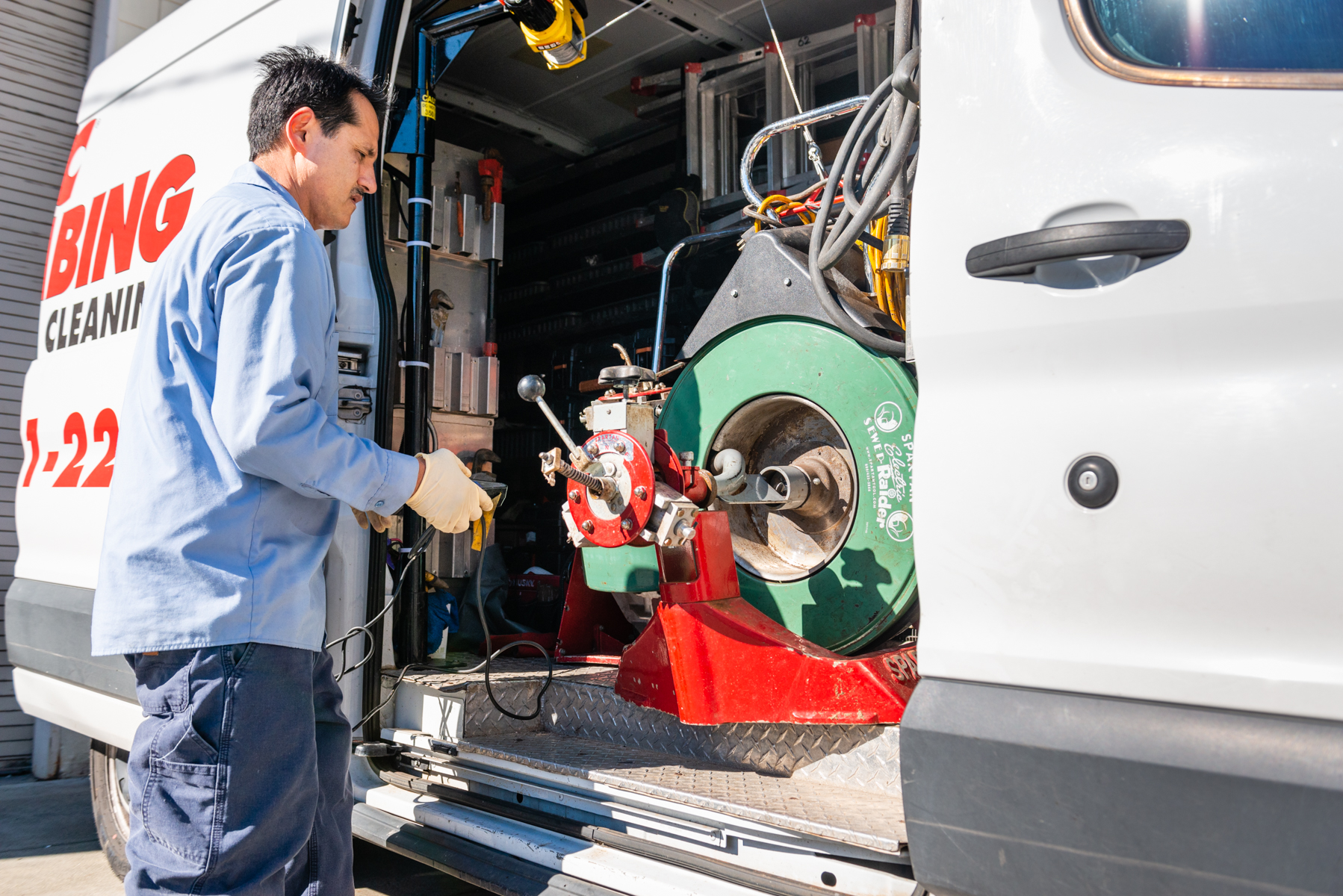A trained technician prepares professional drain equipment in the field, demonstrating the dependable service customers trust from Magic Plumbing Heating & Cooling.