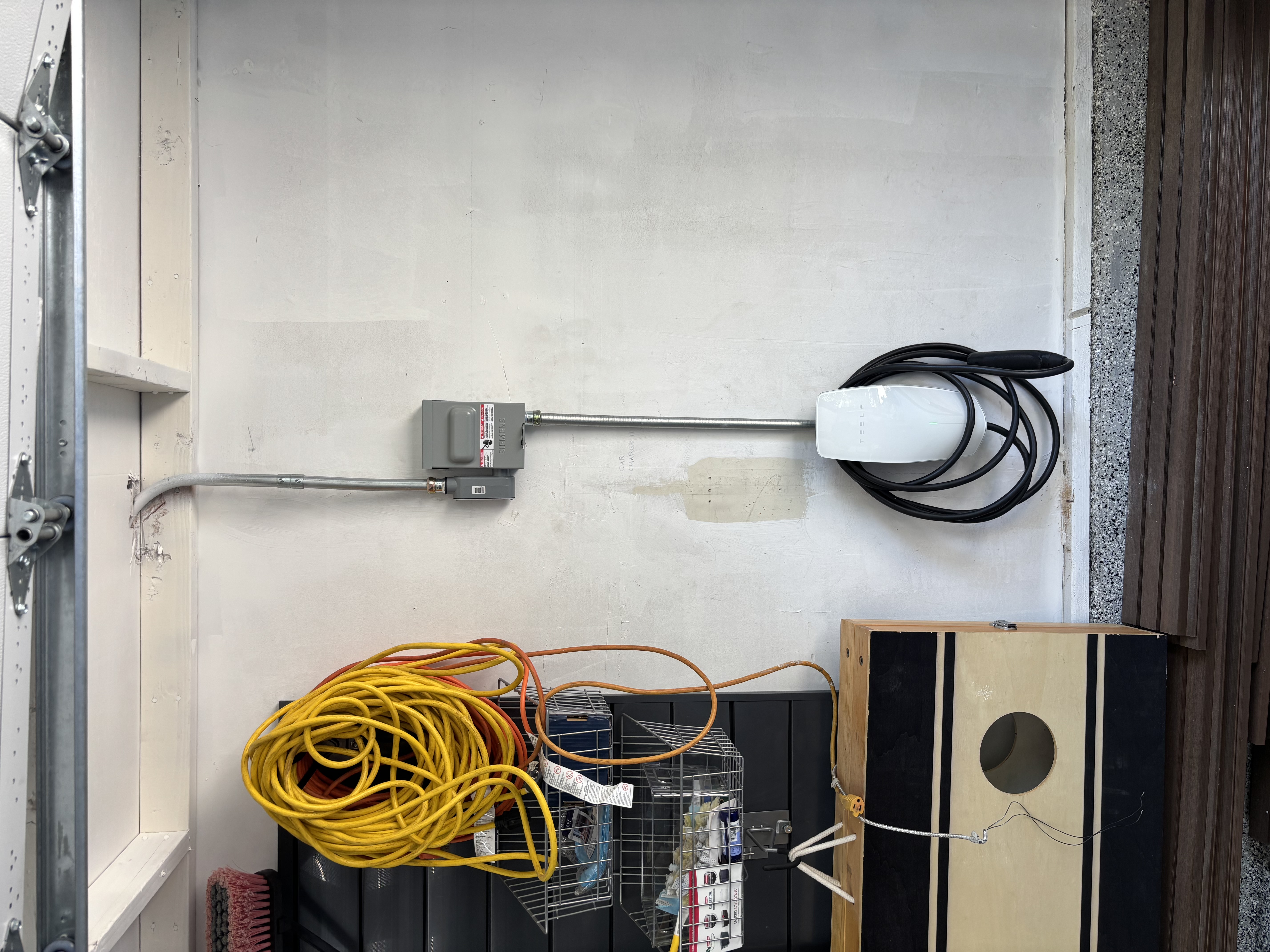 Powell Electric installed a tidy, code-friendly Tesla charger in this garage to deliver reliable home EV charging with confidence.