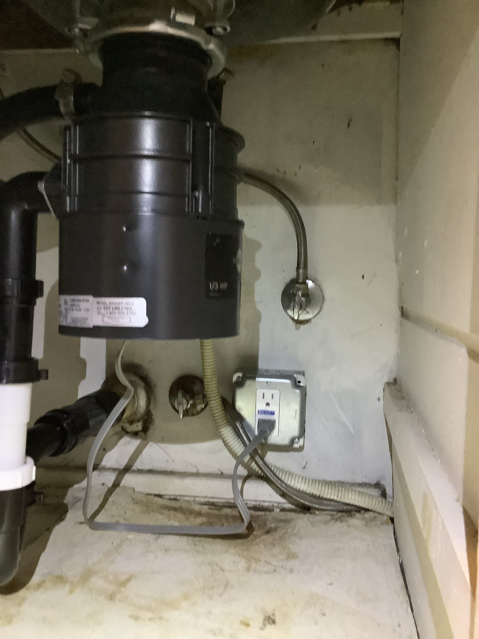 Powell Electric demonstrates safe, professional under-sink electrical work with a grounded GFCI outlet to protect plumbing appliances.