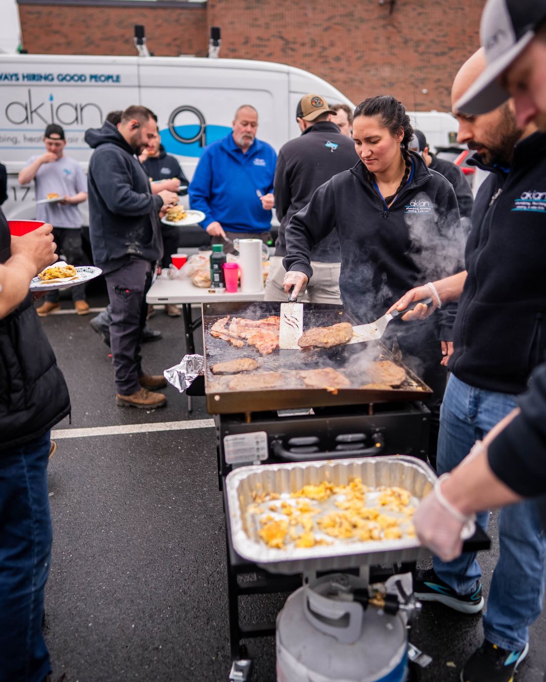 Akian Plumbing, Heating, Cooling & Electric shows its team spirit and dependable service with a friendly on-site cookout that highlights professional care.