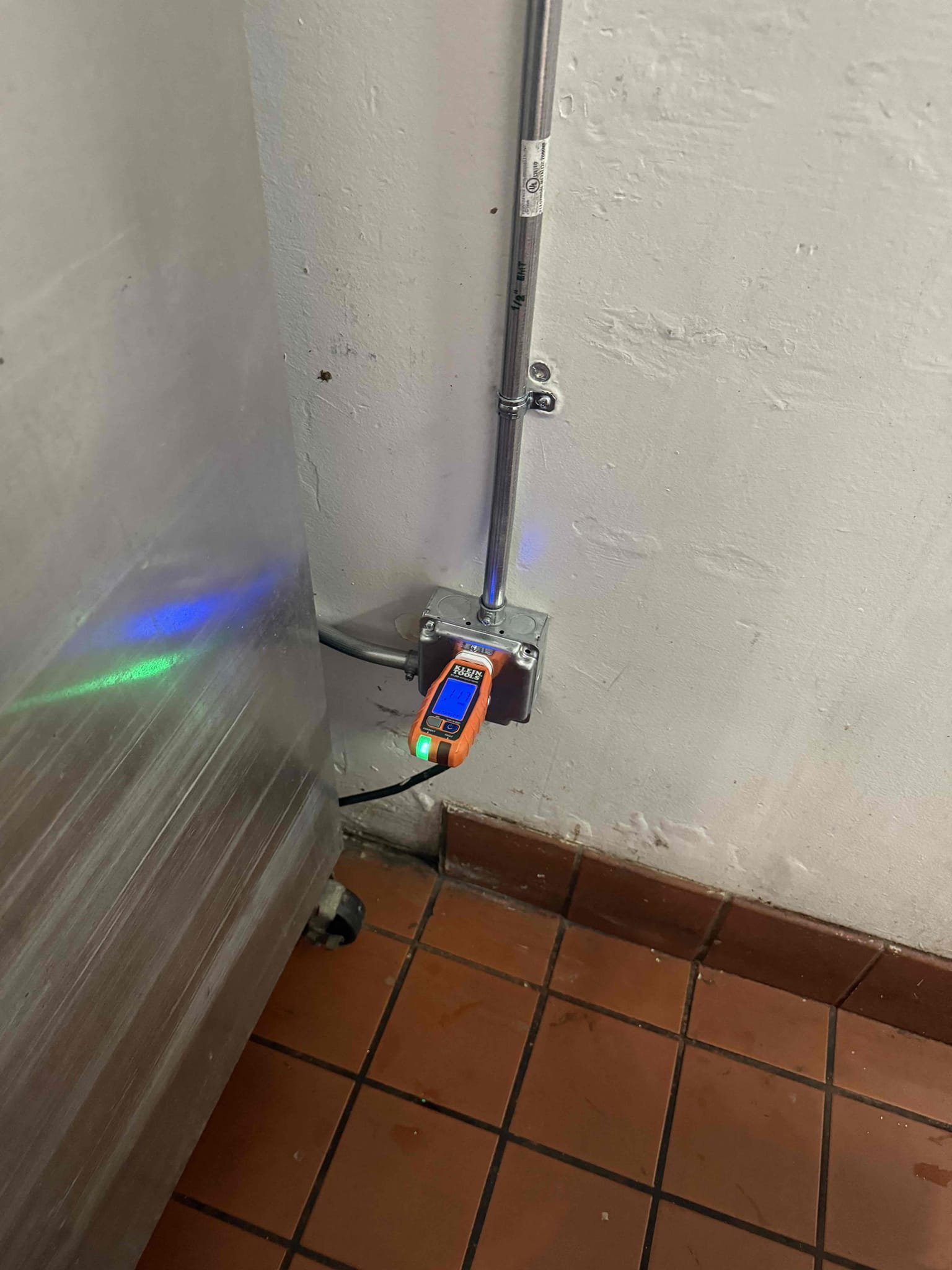 Powell Electric demonstrates careful workmanship and reliable safety checks by installing sturdy conduit and verifying connections with a handheld tester.