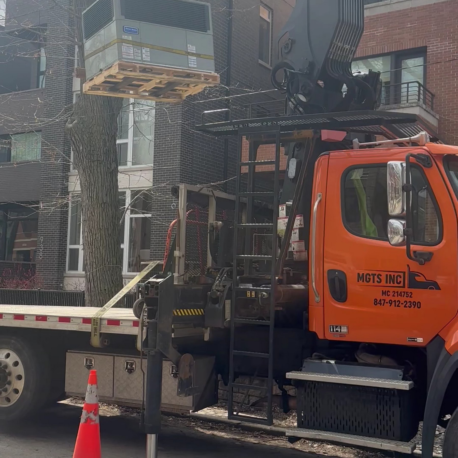 A skilled crew from Oasis Heating and Cooling safely lifts and installs a rooftop HVAC unit, showcasing dependable, professional service.