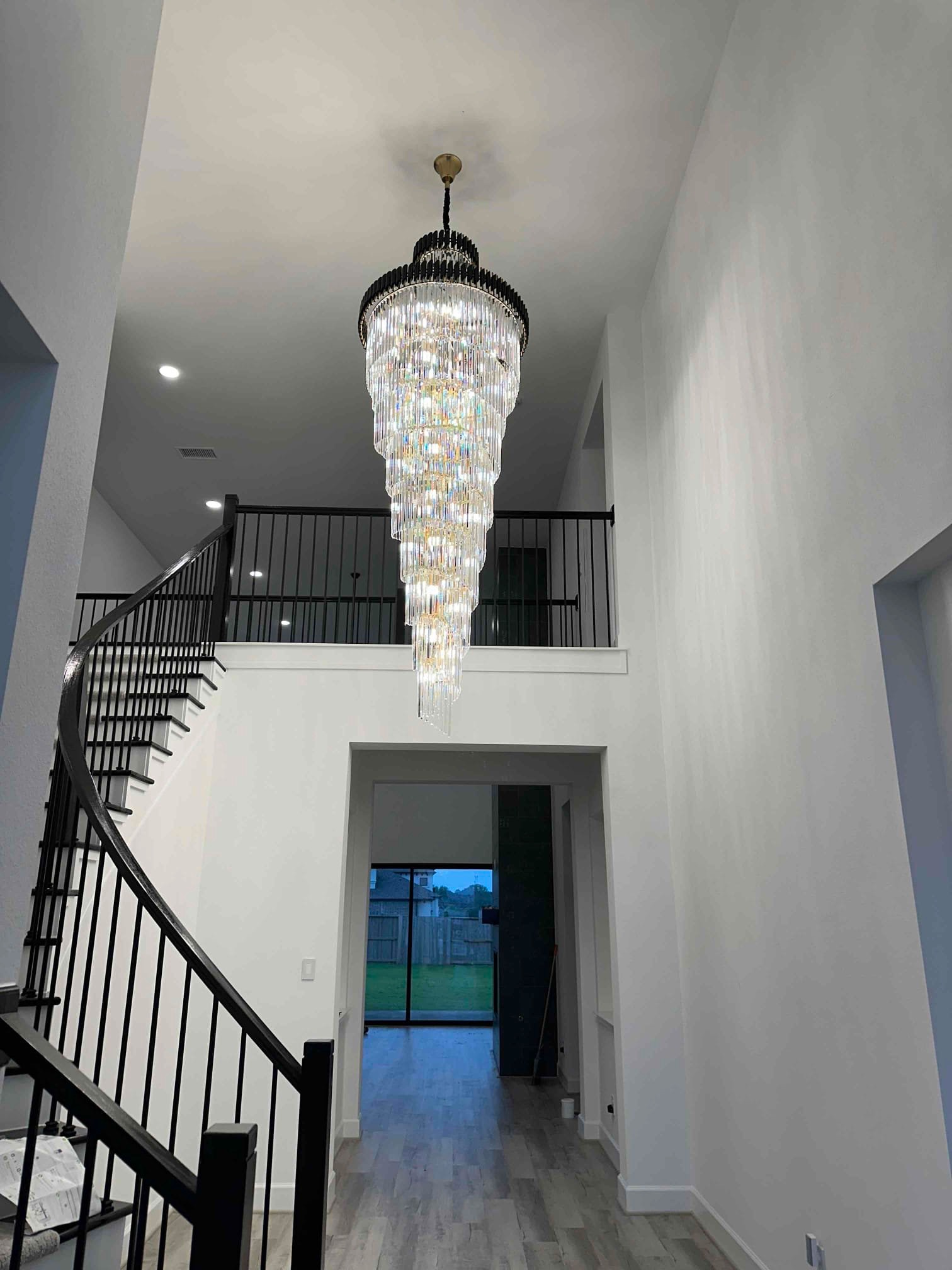 A striking foyer chandelier installed with care highlights West Houston Electric, Inc.'s commitment to beautiful, reliable lighting and craftsmanship.