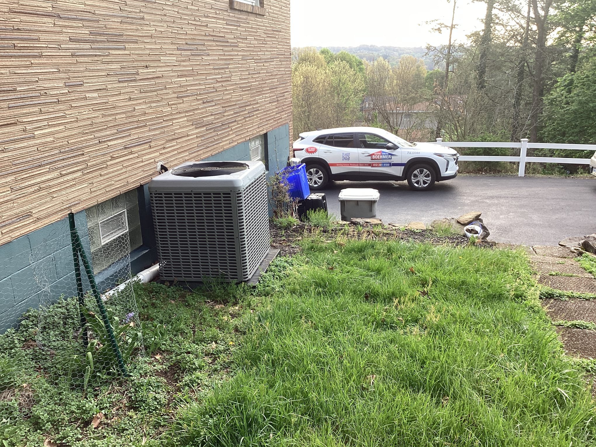 Trust Boehmer Heating & Cooling for professional on-site HVAC service, shown here during routine outdoor condenser maintenance with care.