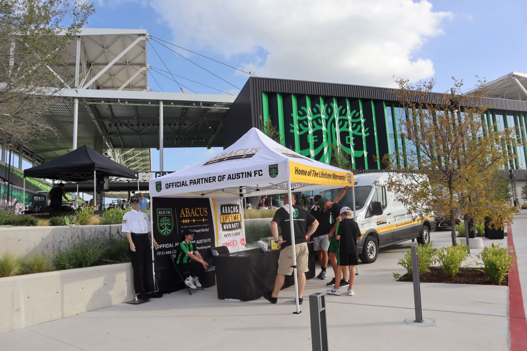 Friendly technicians from Abacus Plumbing, Air Conditioning, & Electrical greet fans at an Austin FC event, showing reliable service and clear warranty confidence.