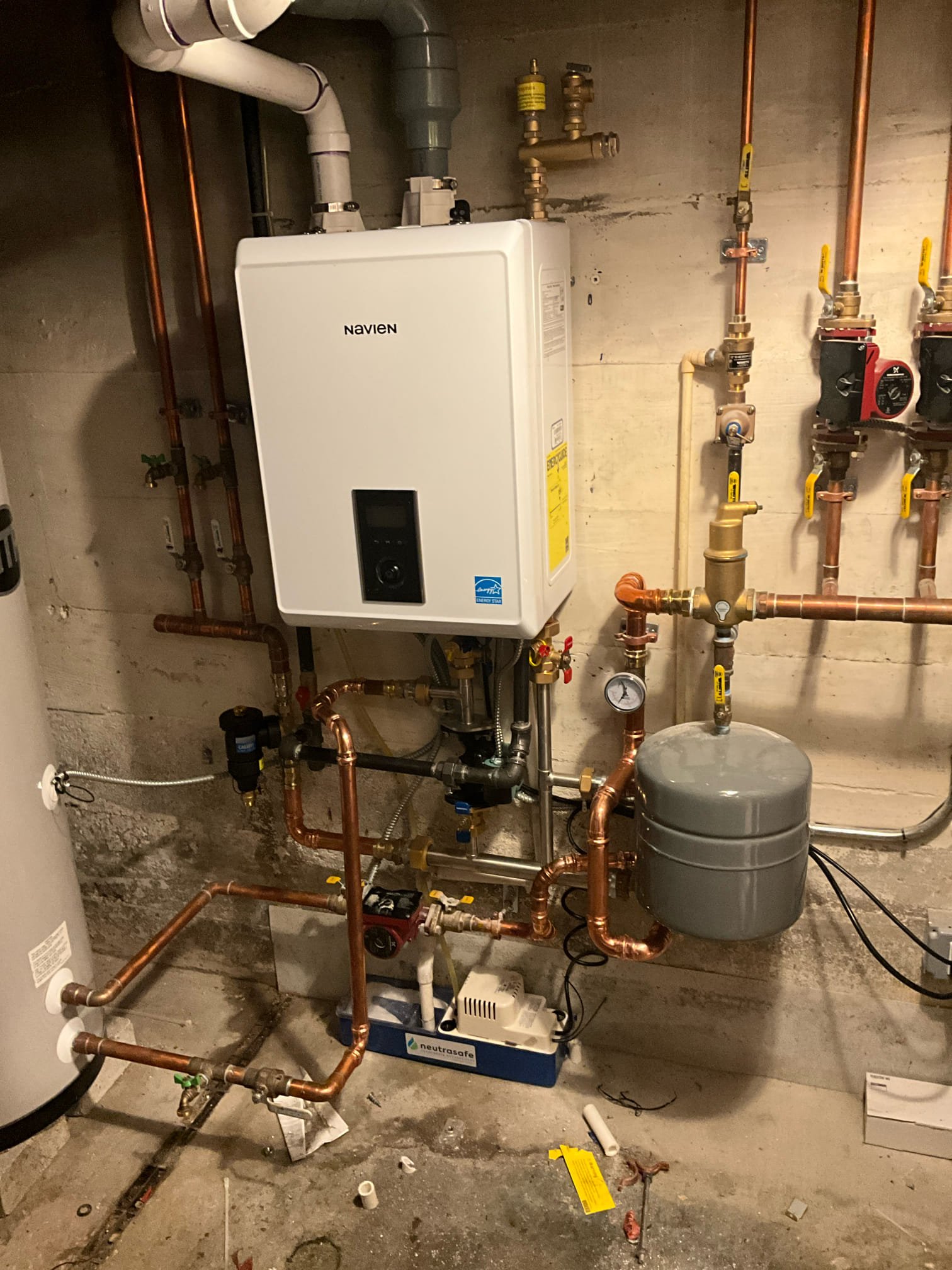A clean, professionally installed Navien boiler and piping system shows the reliable craftsmanship Akian Plumbing, Heating, Cooling & Electric provides for home comfort.