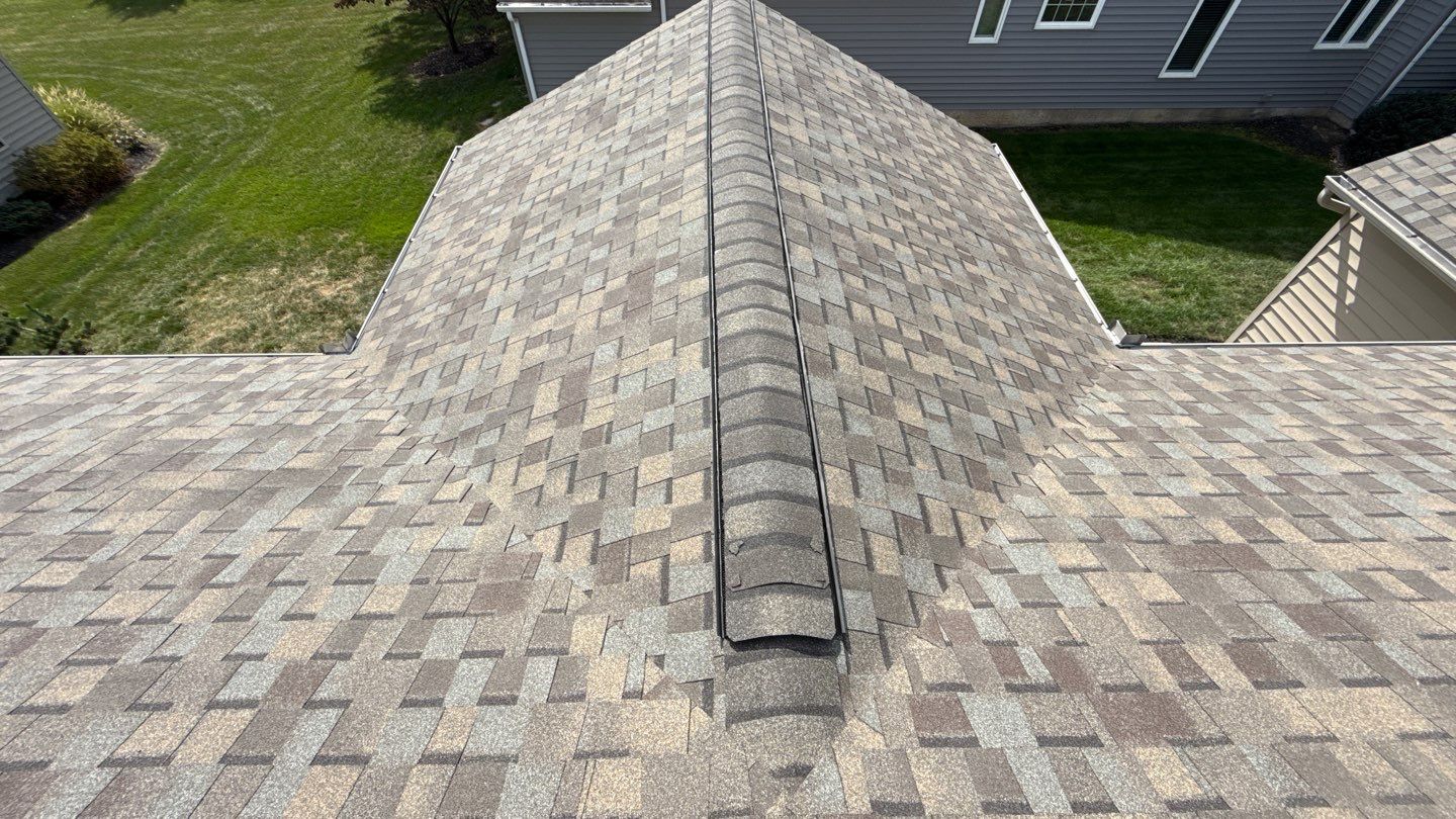Experience reliable craftsmanship and lasting protection with Mosaic Roofing & Exteriors, shown here on a neatly installed asphalt shingle ridge.