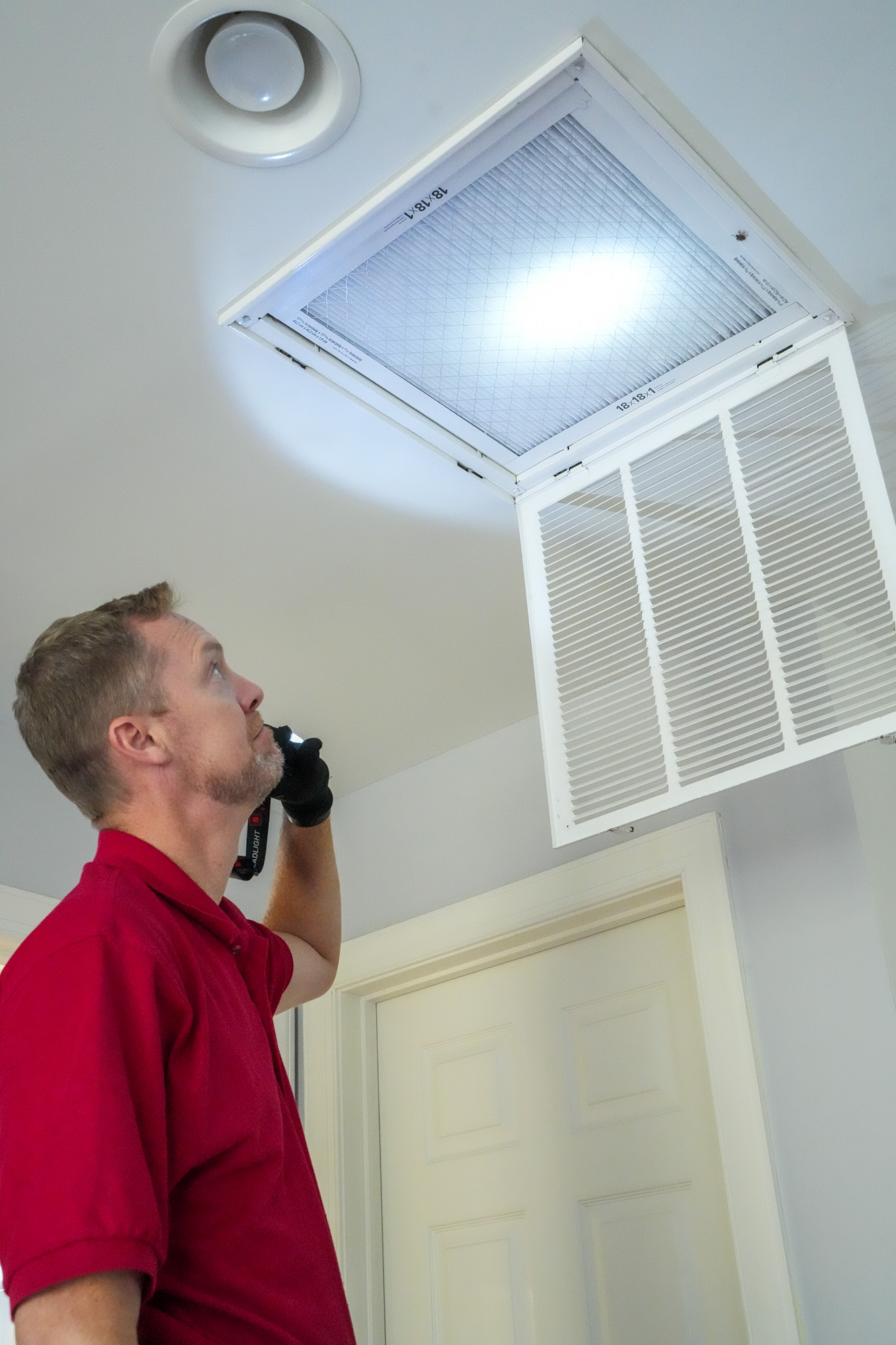 A Parrish Services technician performs a careful HVAC inspection, showing attention to detail and dependable home comfort service.
