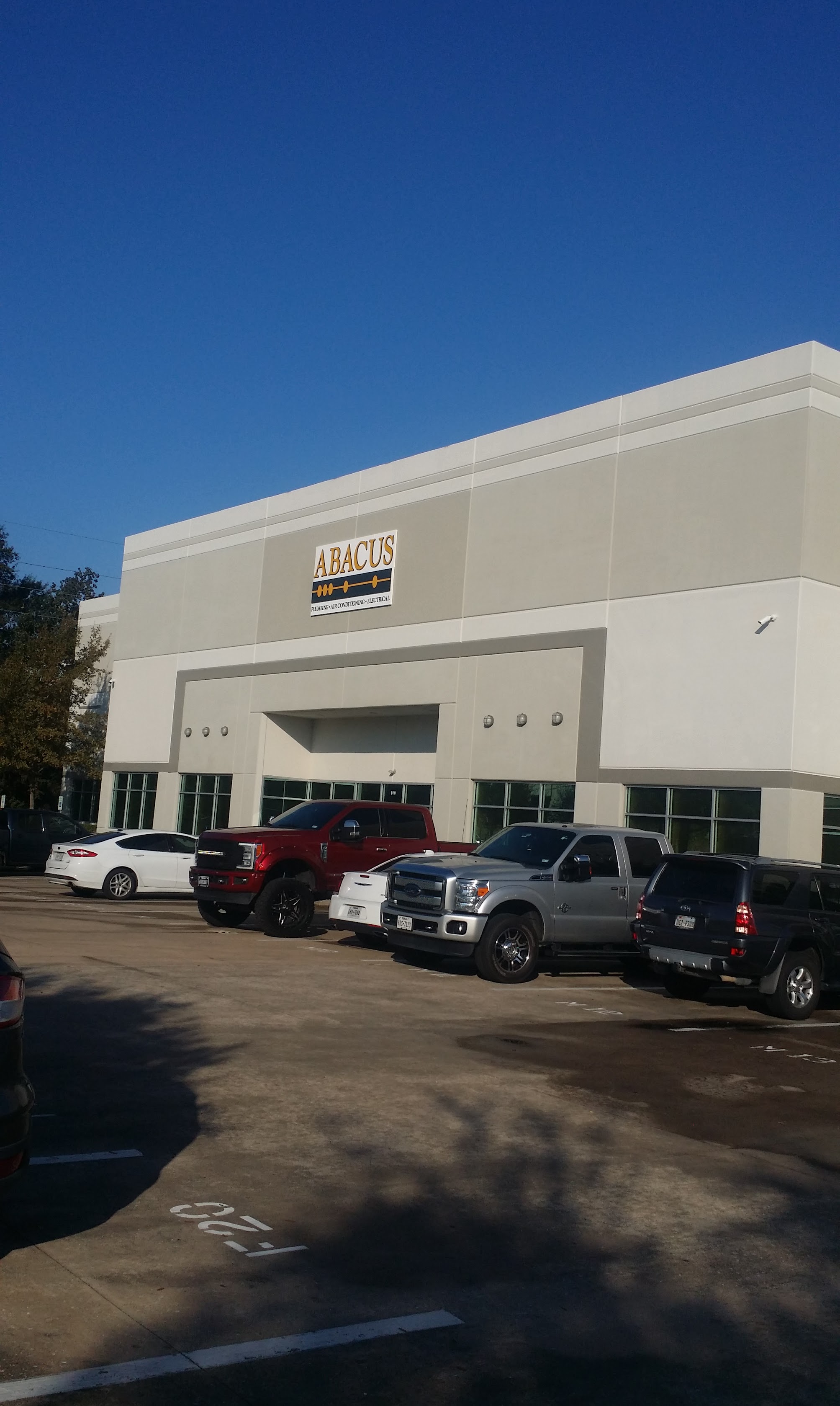 A clean, professional storefront and fleet showcase Abacus Plumbing, Air Conditioning & Electrical as a reliable team ready to serve customers.