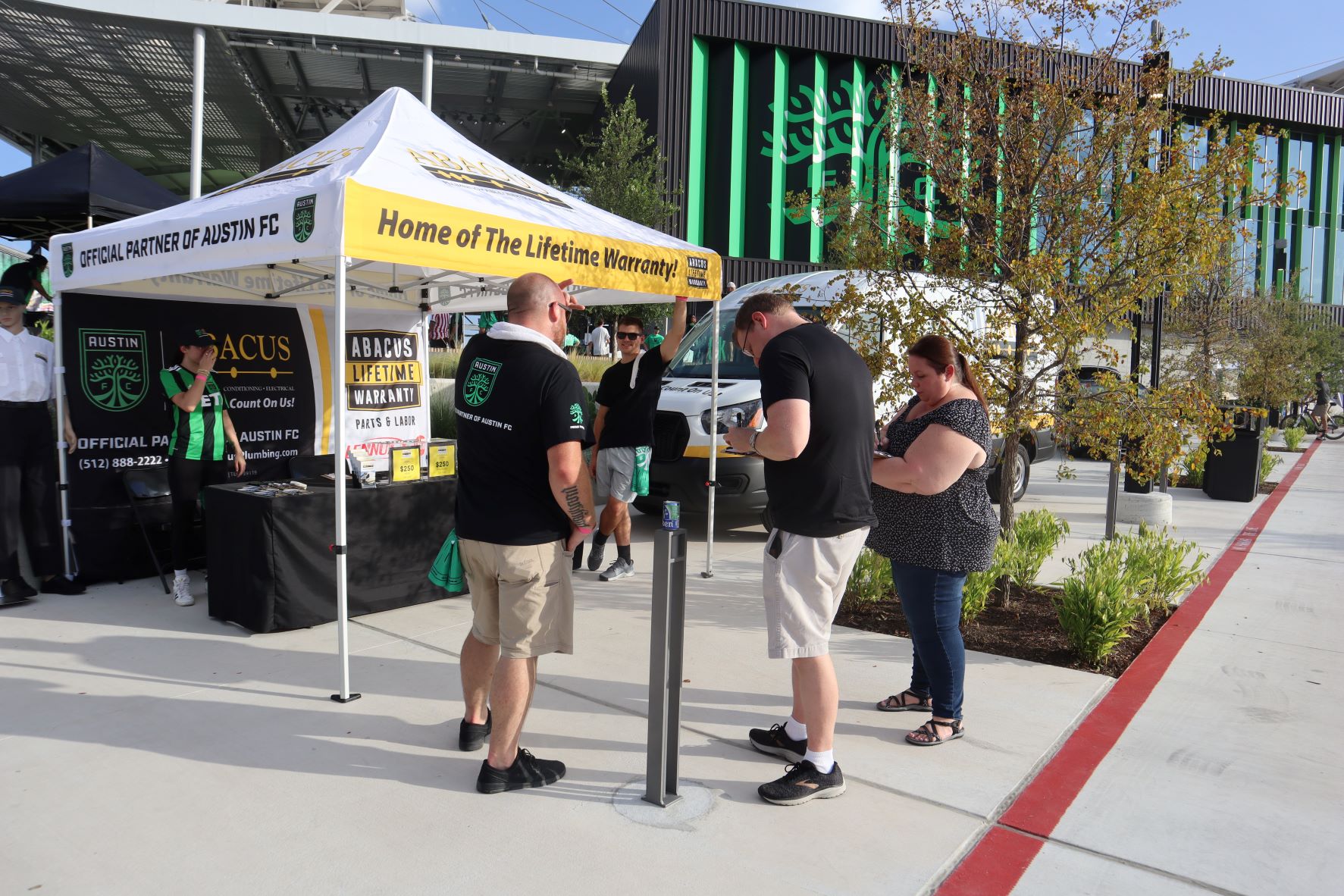 Friendly staff at Abacus Plumbing, Air Conditioning, & Electrical showcase their lifetime warranty while engaging local customers with confidence.