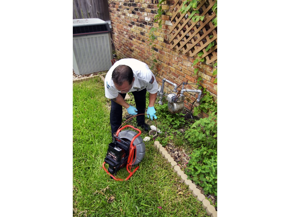 A trained technician from Abacus Plumbing, Air Conditioning & Electrical demonstrates careful, professional drain service to protect your home and utilities.