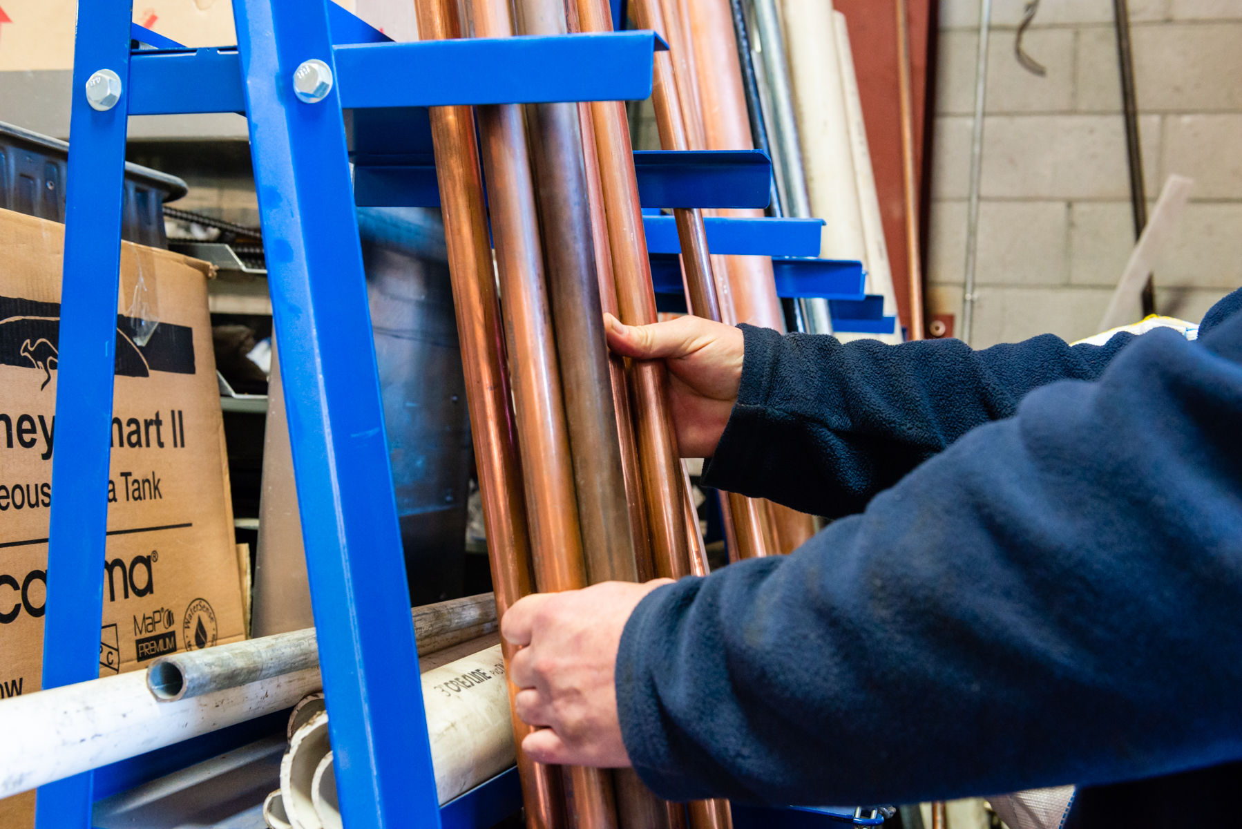 Skilled technicians carefully handle high-quality copper piping, showcasing the craftsmanship and reliability customers trust from Magic Plumbing Heating & Cooling.