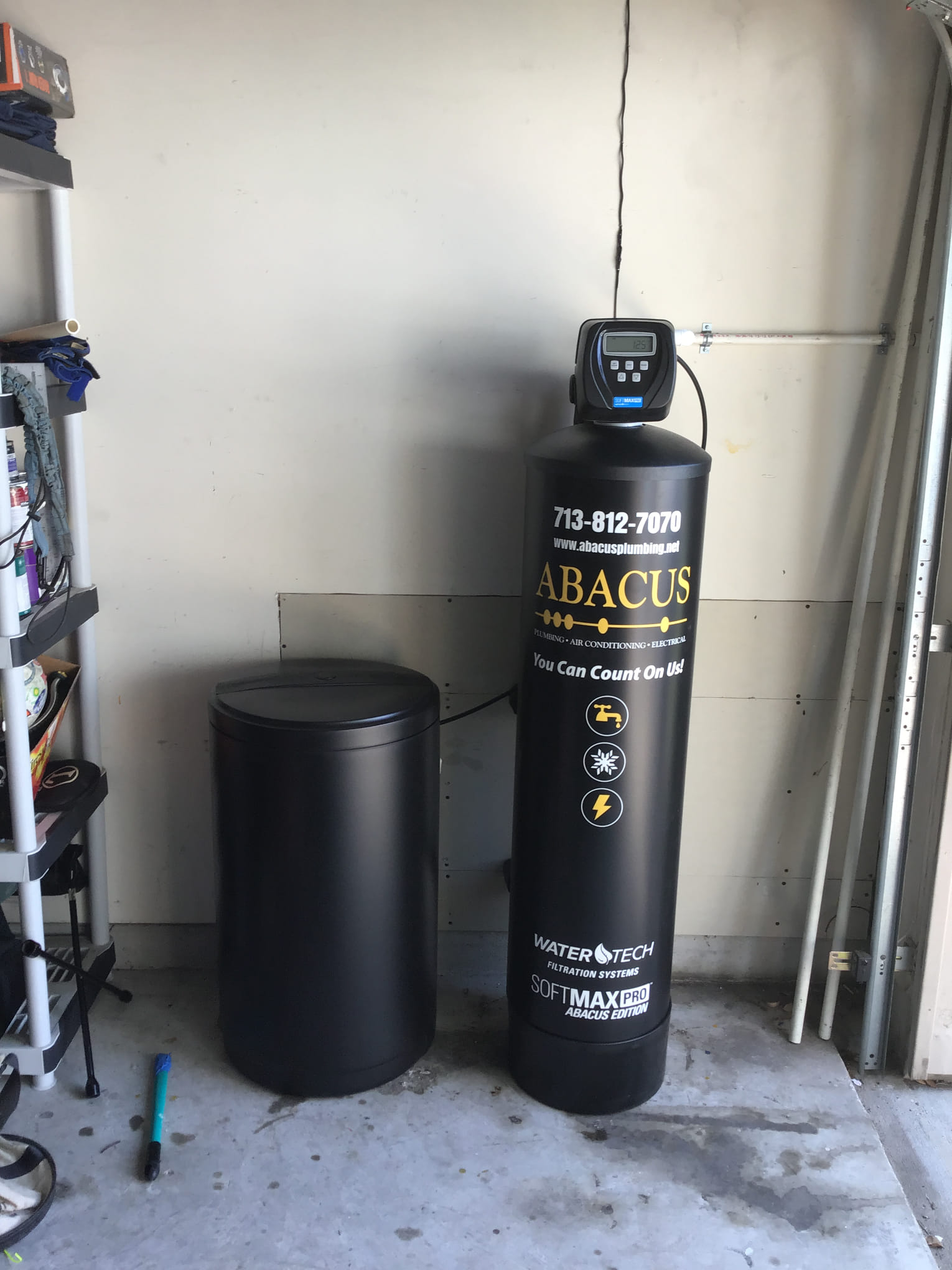 A tidy residential water softener installation shows the reliable craftsmanship customers expect from Abacus Plumbing, Air Conditioning & Electrical.