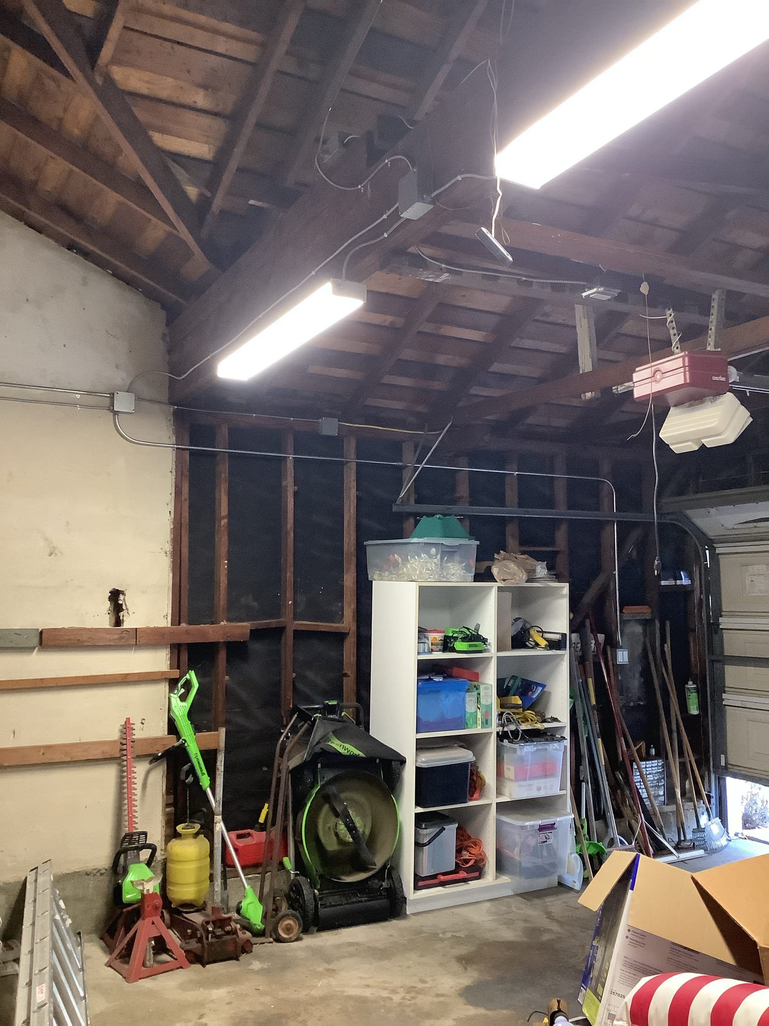 Powell Electric restored safe, well-lit garage wiring with tidy conduit runs and reliable fixtures to improve workspace safety and usability.