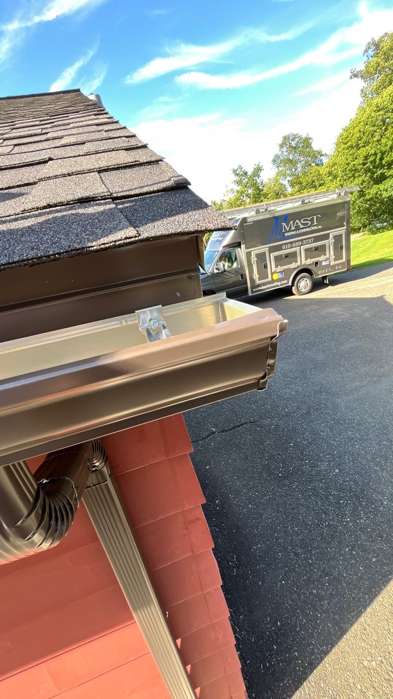 Mast Roofing & Construction demonstrates durable, precise gutter installation to protect your home while showing dependable on-site professionalism.
