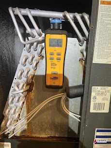 A Cardinal Plumbing Heating & Air Inc technician performs a thorough diagnostic inspection to spot corrosion and ensure reliable HVAC performance.