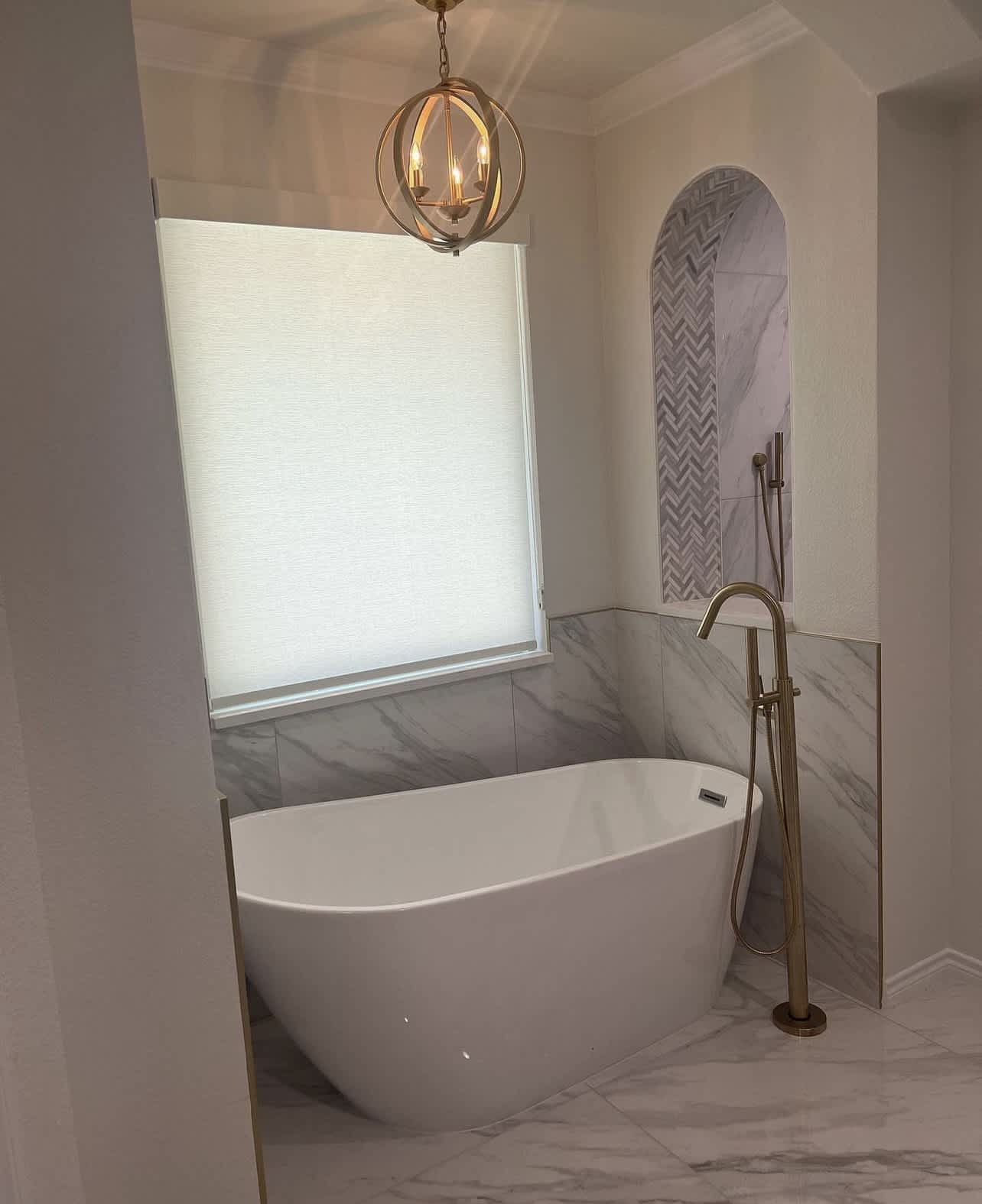 A beautifully finished freestanding tub and gold floor faucet showcase Rise Plumbing Systems' craftsmanship and attention to elegant bathroom details.