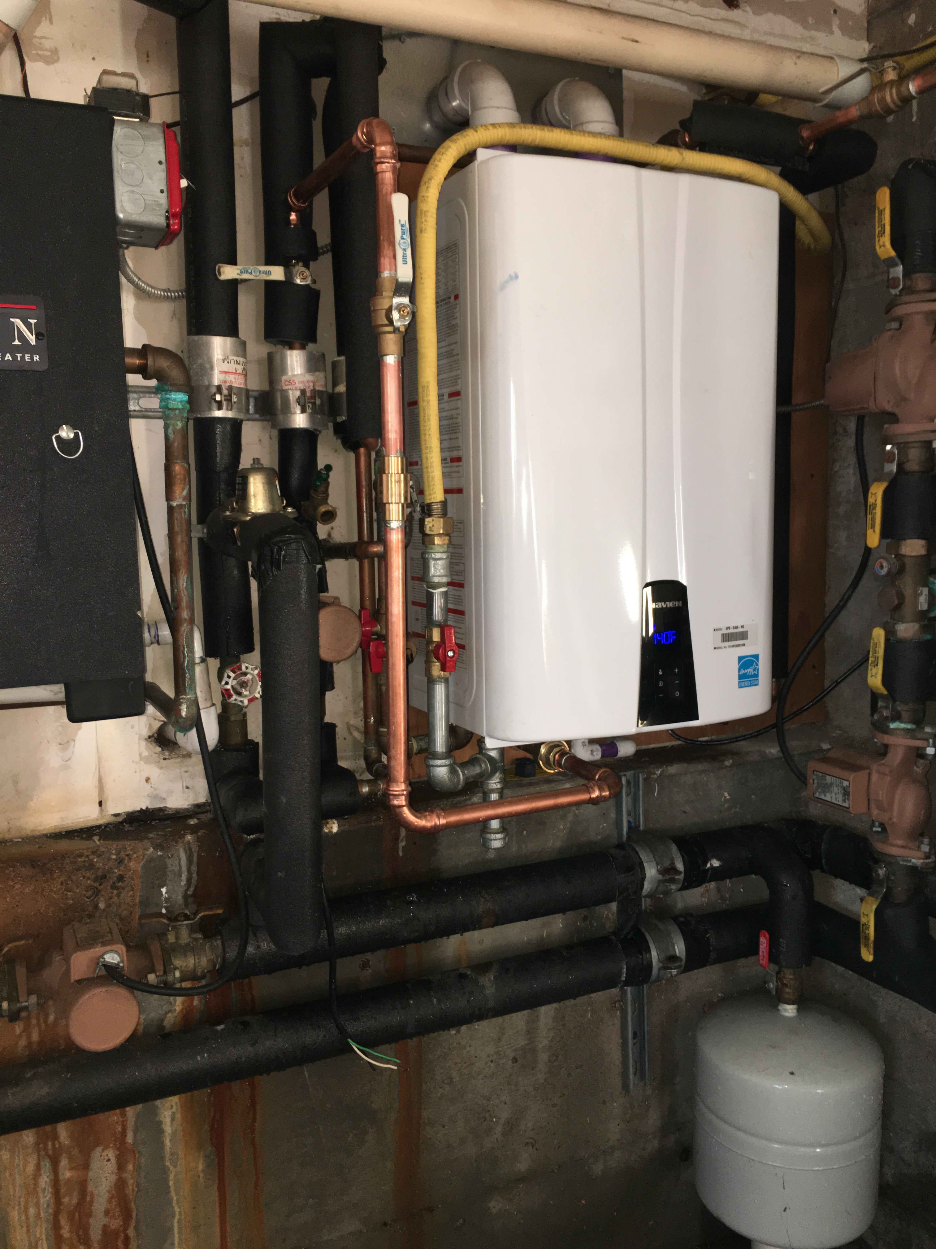 Cleanly installed tankless boiler with organized copper piping highlights the reliable craftsmanship customers expect from Magic Plumbing Heating & Cooling.