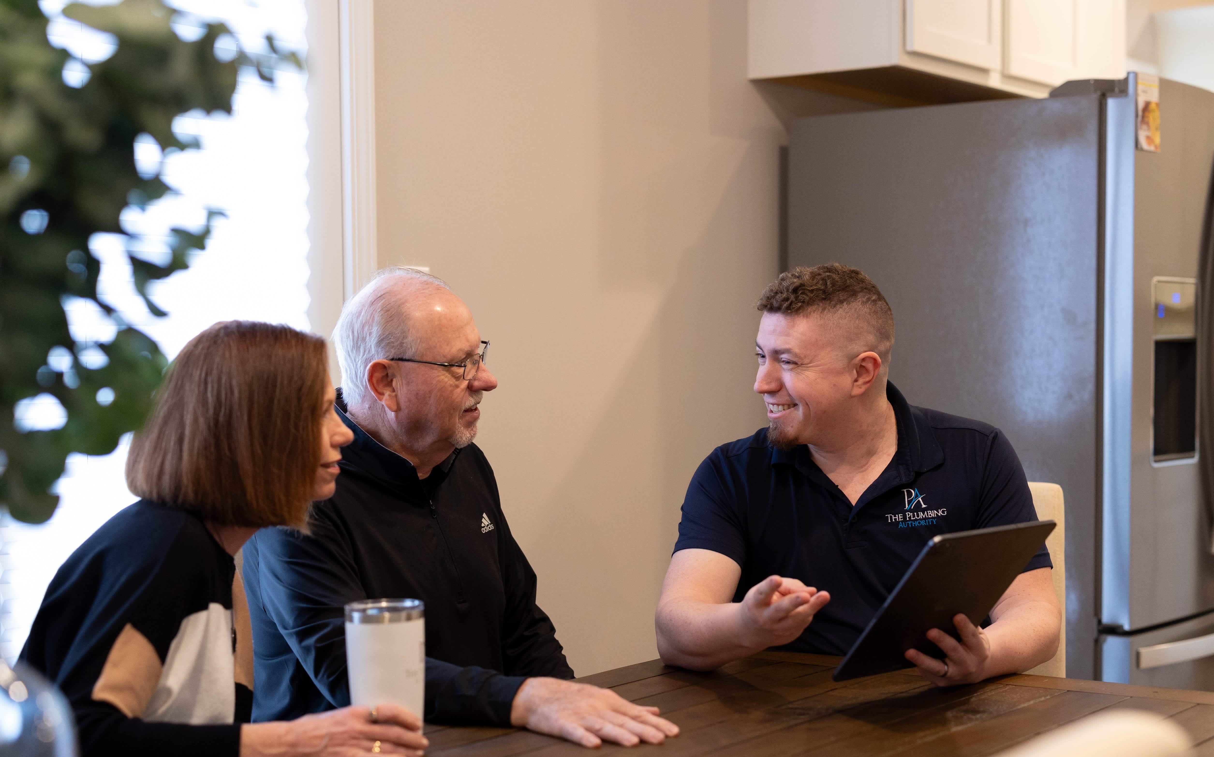 Smiling and professional, The Plumbing Authority walks homeowners through solutions on a tablet to build trust and clear expectations.