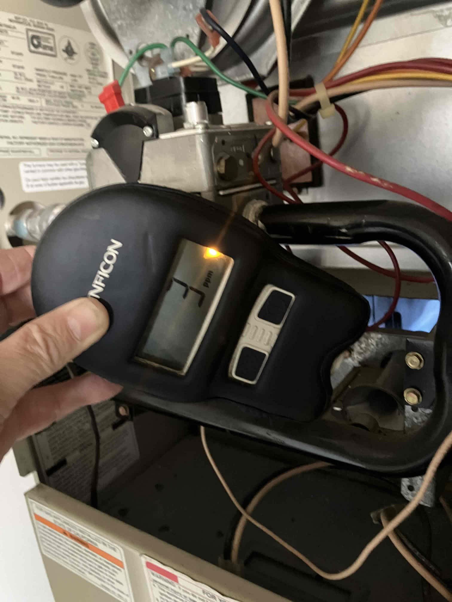 Focused diagnostic work inside a furnace shows the care and expertise Magic Plumbing Heating & Cooling brings to every repair.
