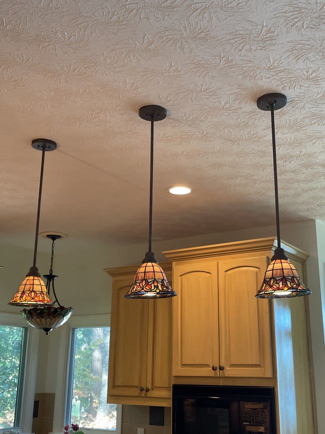 Bright, handcrafted stained glass pendants add warmth and visible craftsmanship to this kitchen, installed by C&T Electric LLC.