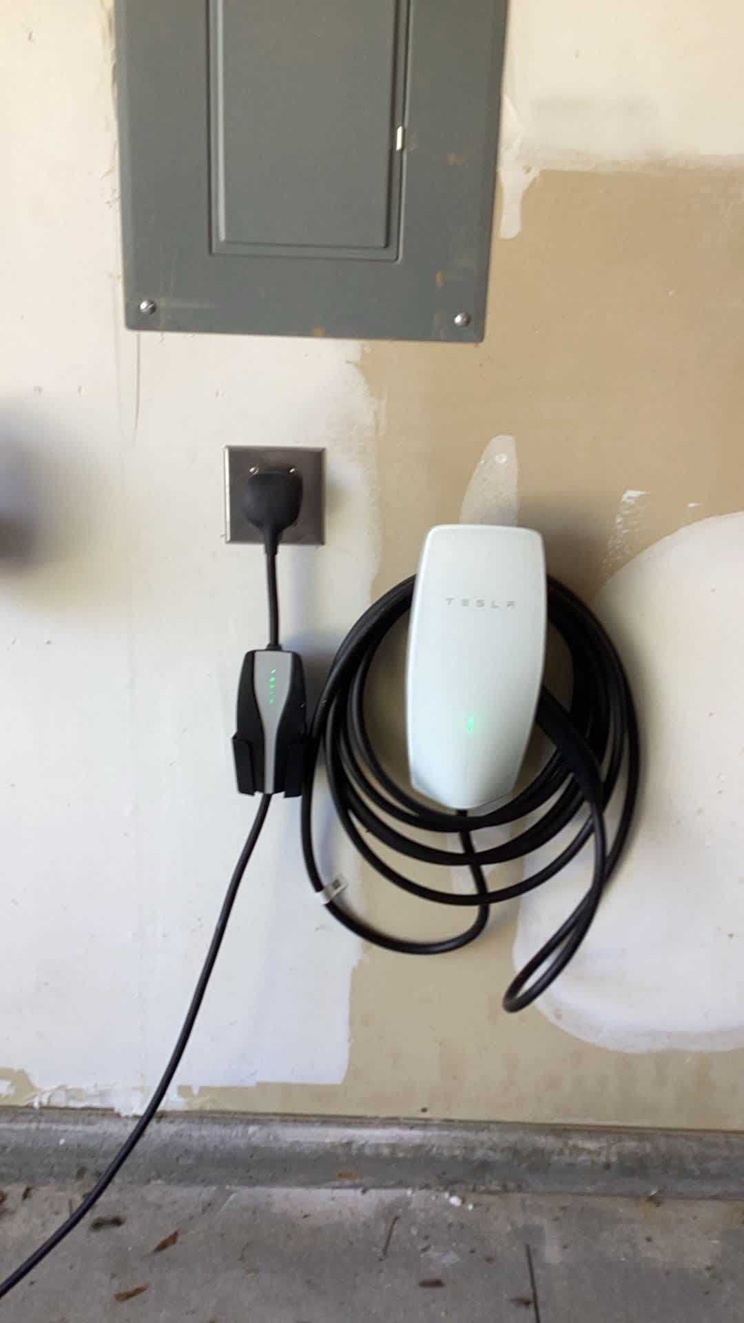 A clean, professionally installed Tesla wall charger in a residential garage highlights dependable, lasting electrical work by Atomic Electric Service Inc.