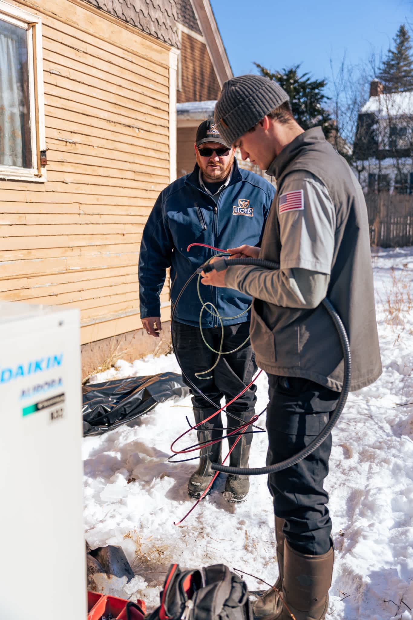 Skilled Lloyd Plumbing, Heating, Air, Electrical technicians perform reliable outdoor HVAC work in winter, showing professionalism and care.