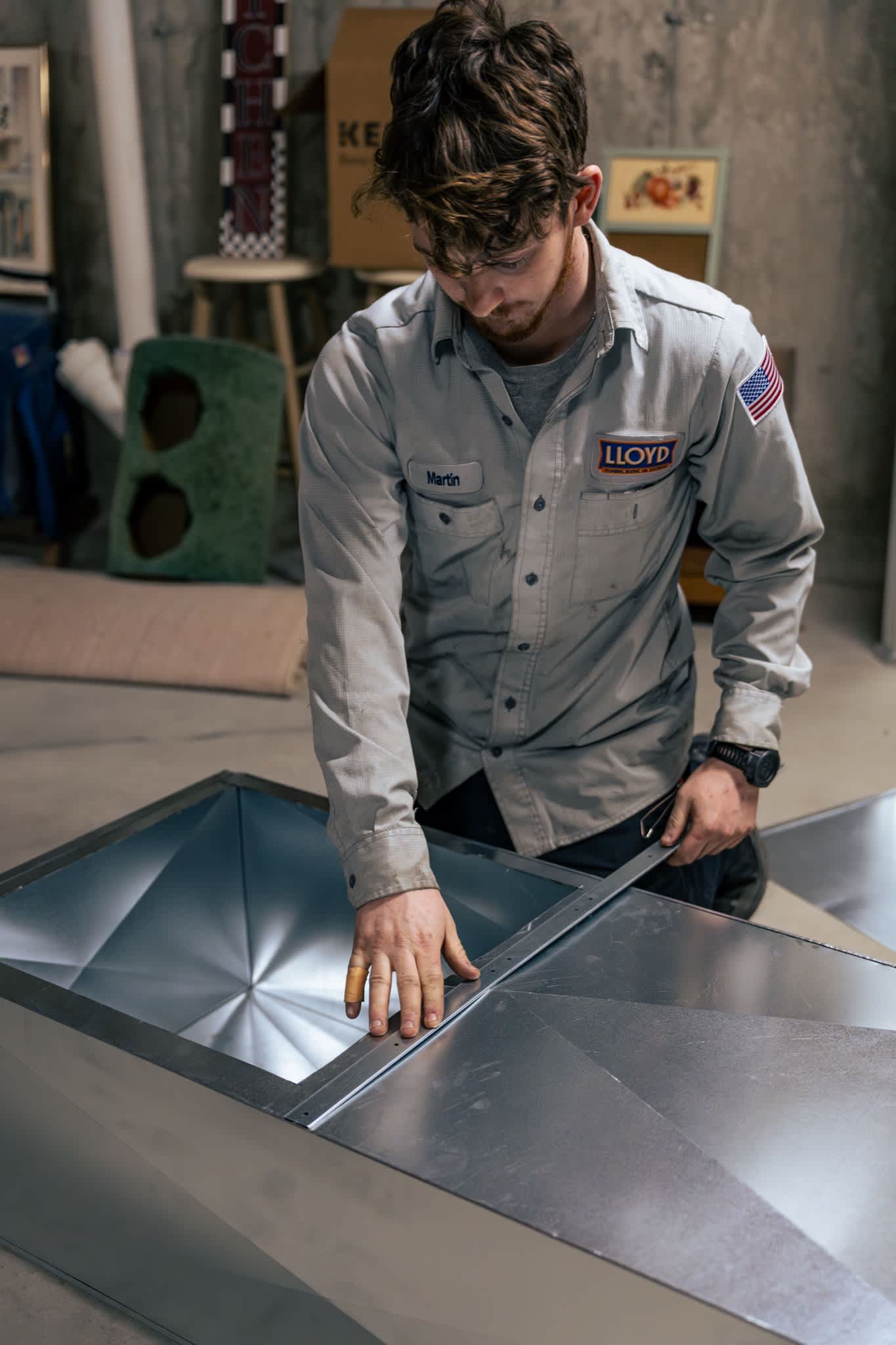 A skilled Lloyd Plumbing, Heating, Air, Electrical technician demonstrates careful craftsmanship while fitting sheet-metal ductwork to ensure lasting performance for your home.