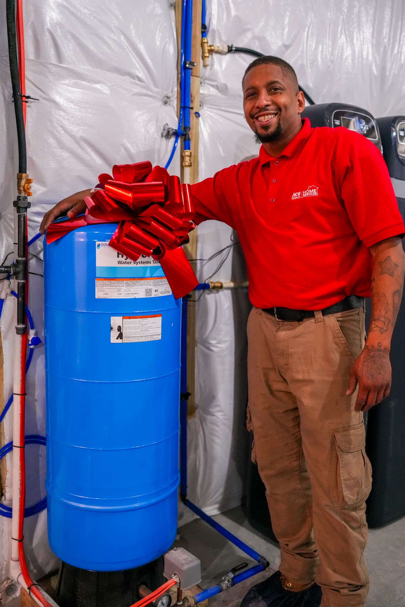 A satisfied Parrish Services technician proudly presents a completed water system installation, showcasing dependable craftsmanship and care.