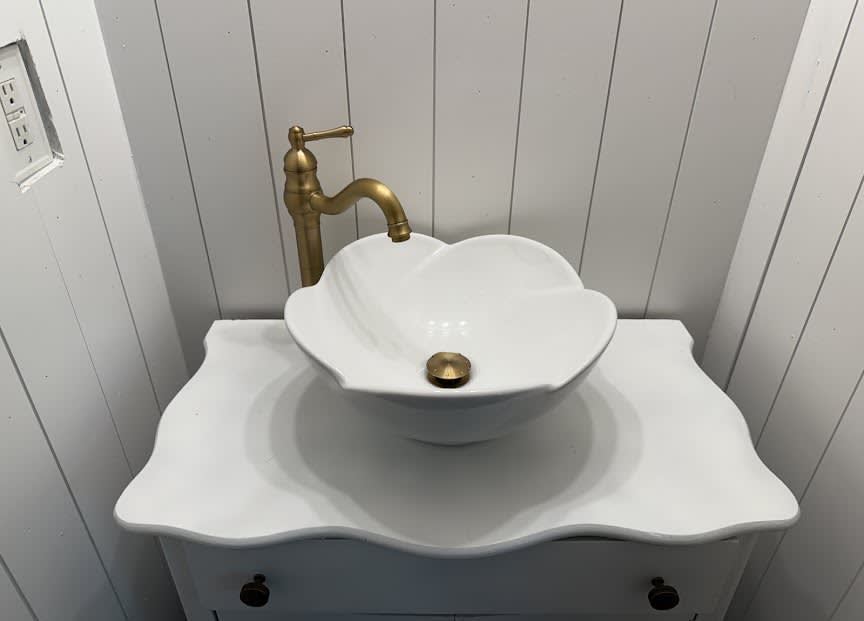 A beautifully installed vessel sink with brass fixtures showcases the careful craftsmanship customers expect from Abacus Plumbing, Air Conditioning, & Electrical.