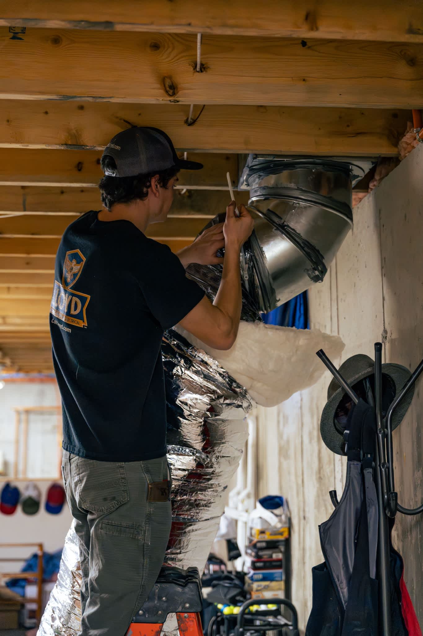 Reliable craftsmanship in tight spaces shows Lloyd Plumbing, Heating, Air, Electrical securing ductwork to improve comfort and efficiency.