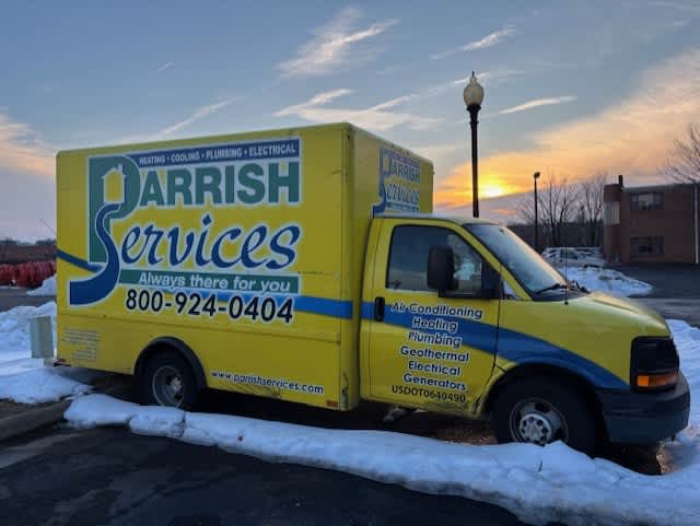 A well-branded Parrish Services truck ready for service at sunset, showing dependable professionalism and clear contact information.