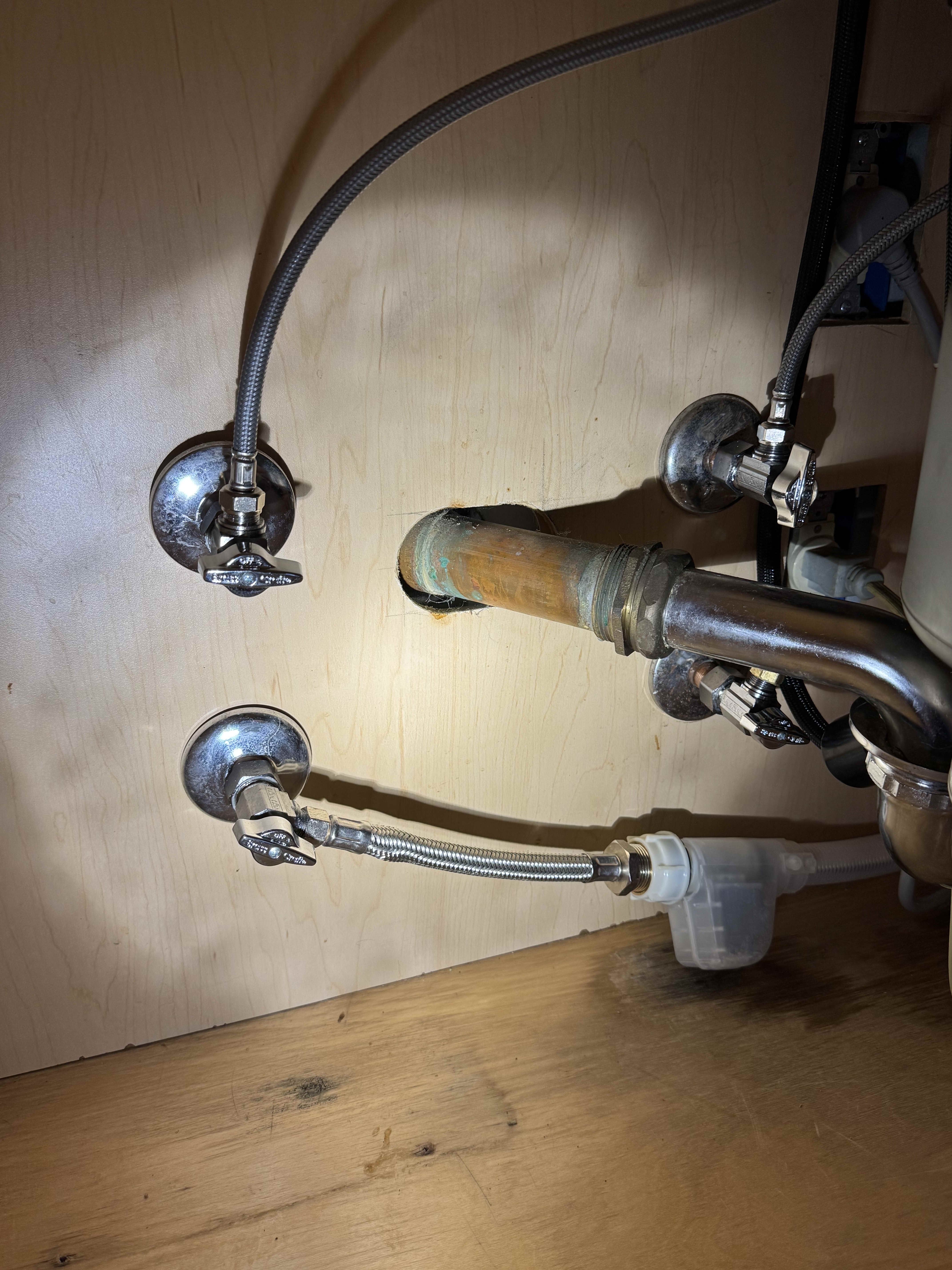 Cleanly installed shutoff valves and supply lines under a sink show the careful workmanship customers trust from Big Island Plumbing.
