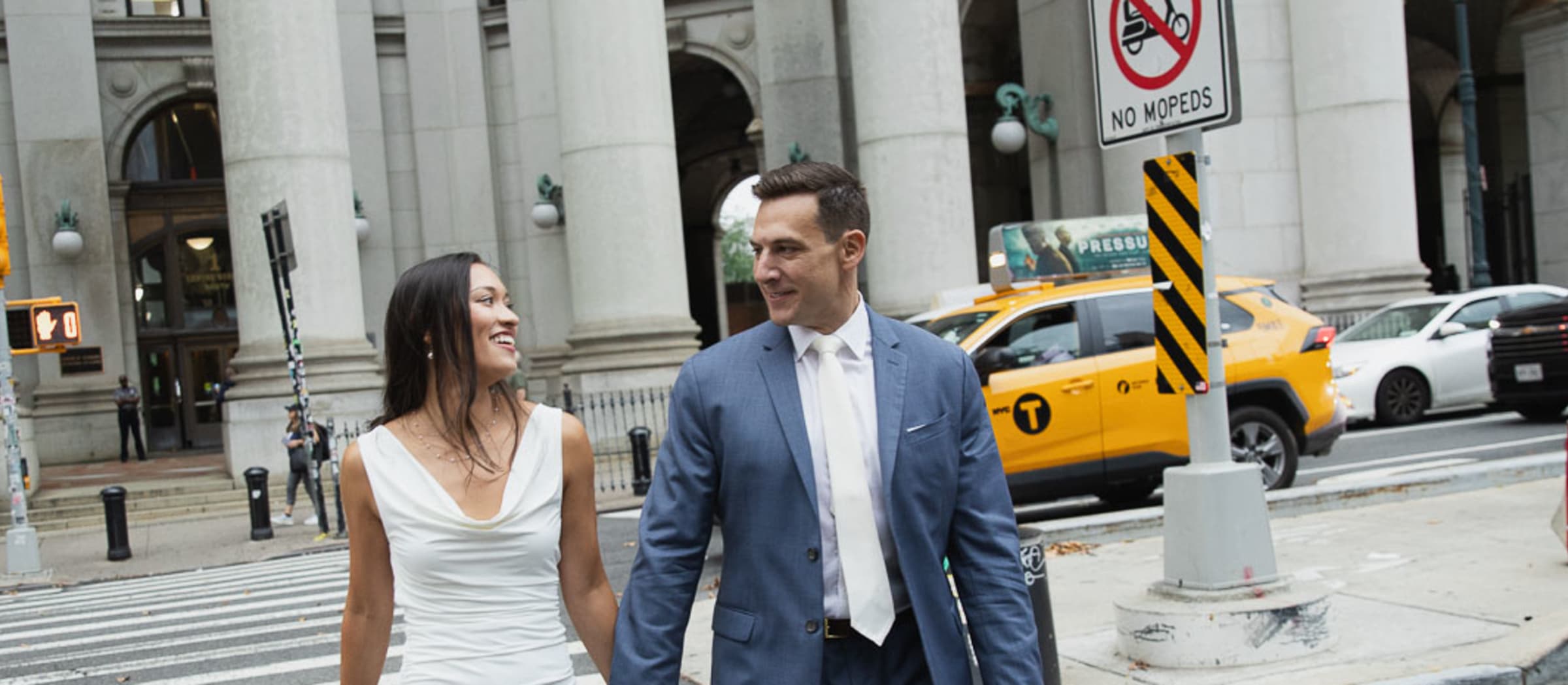 Mikayla and Michael holding hands as they cross the street near City Hall in Lower Manhattan on their wedding day