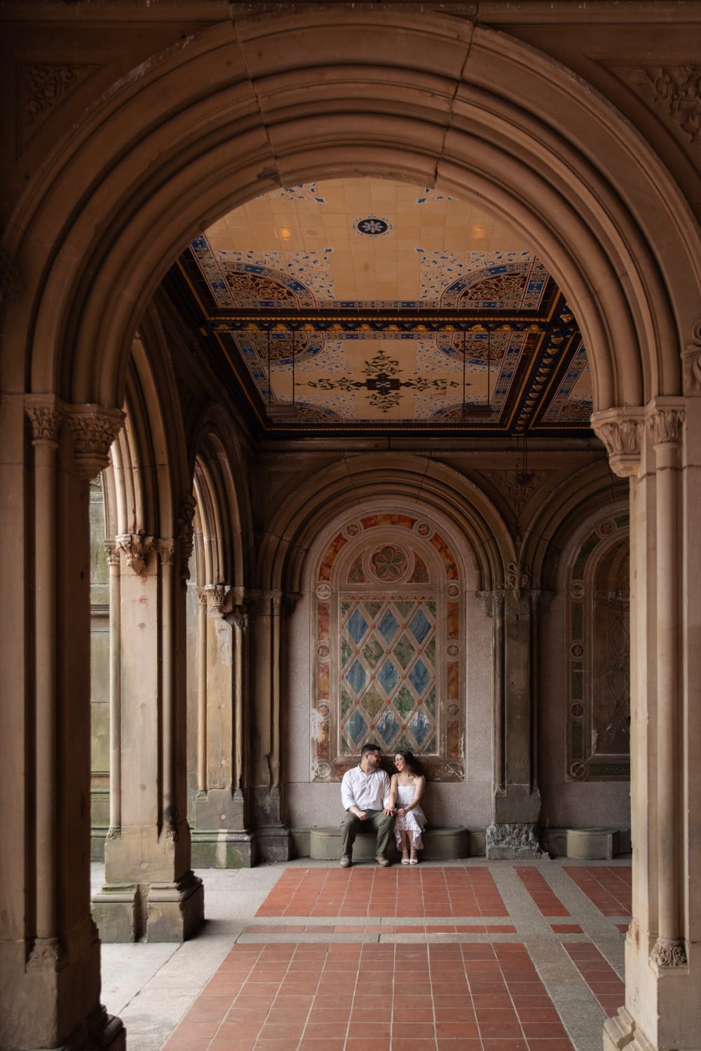 The couple sitting together at the end of the arcade beneath Bethesda Terrace