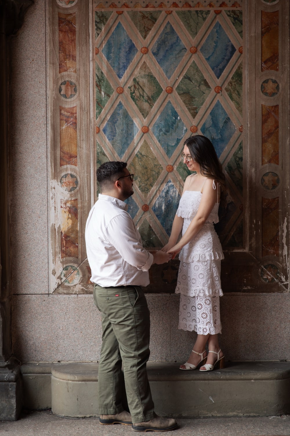 Sydney and Braden holding hands in front of the tiled walls of the Bethesda Terrace arcade