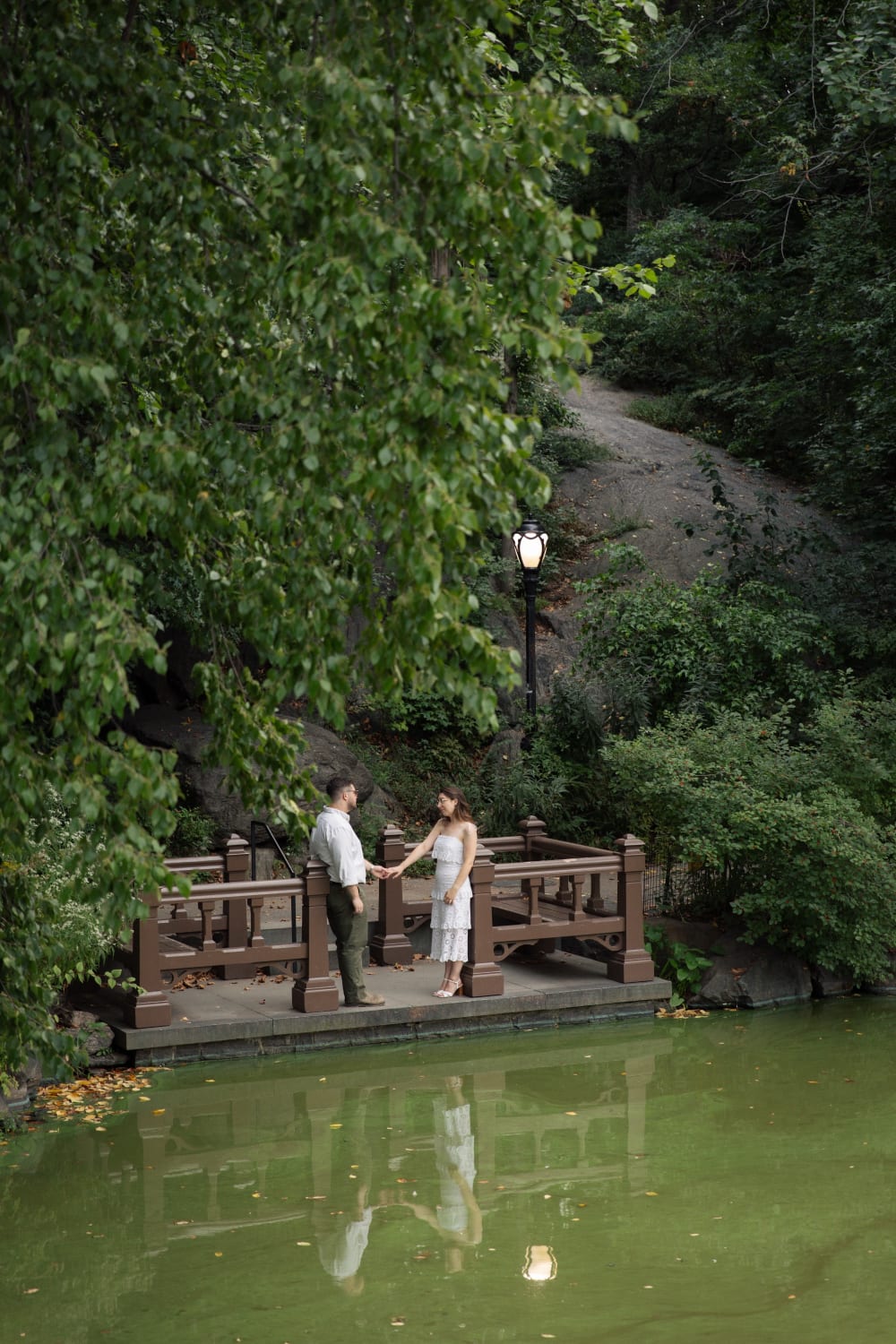 Sydney and Braden on a rustic wooden landing over the water in Central Park