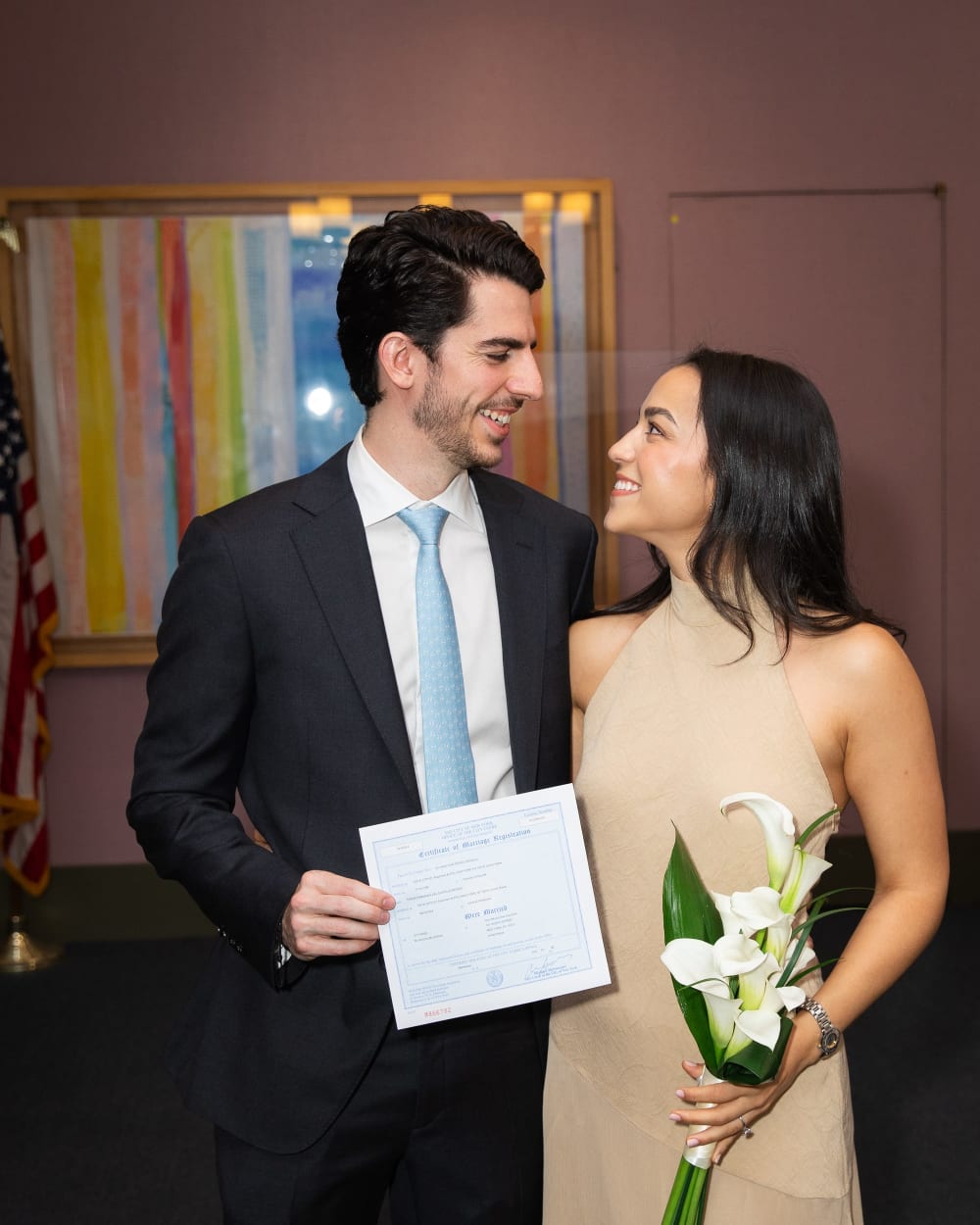 Alvaro and Maria holding their marriage certificate after the City Hall ceremony
