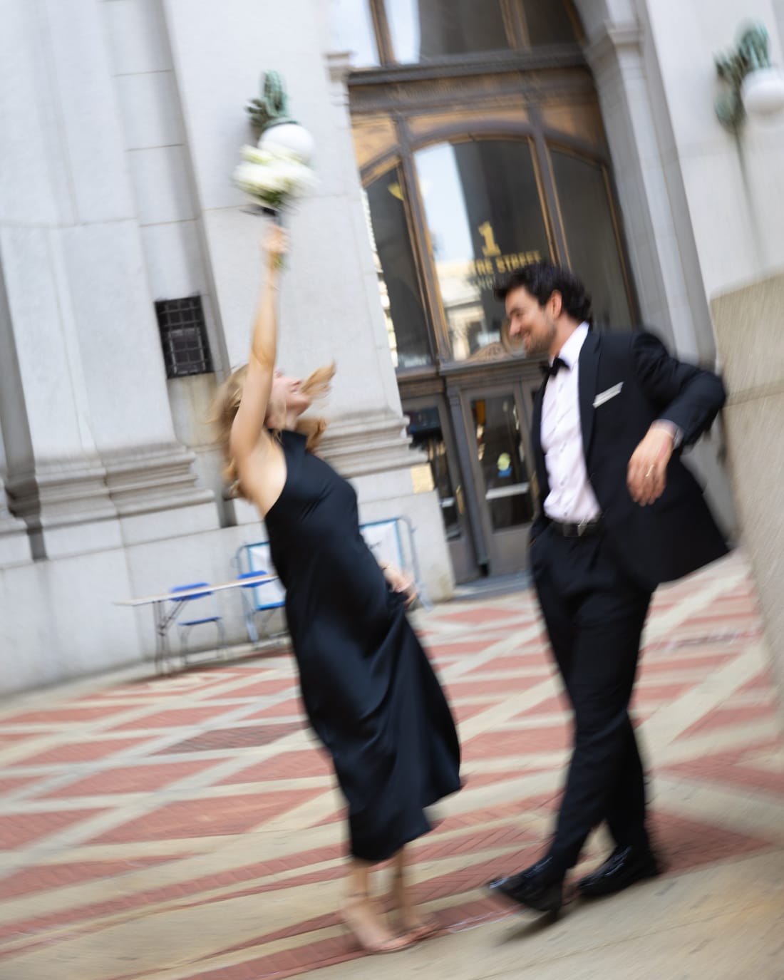 Joana throwing her bouquet in the air outside the Office of the City Clerk