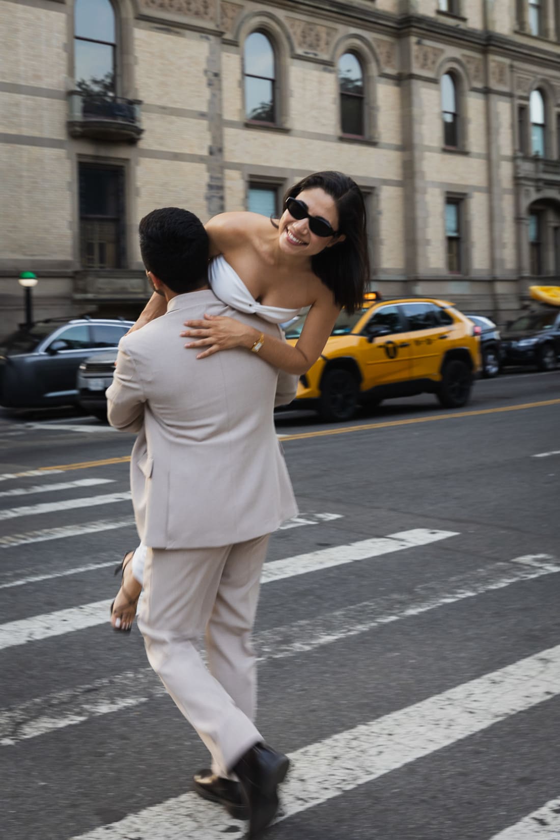 A man carrying a woman across a street in New York