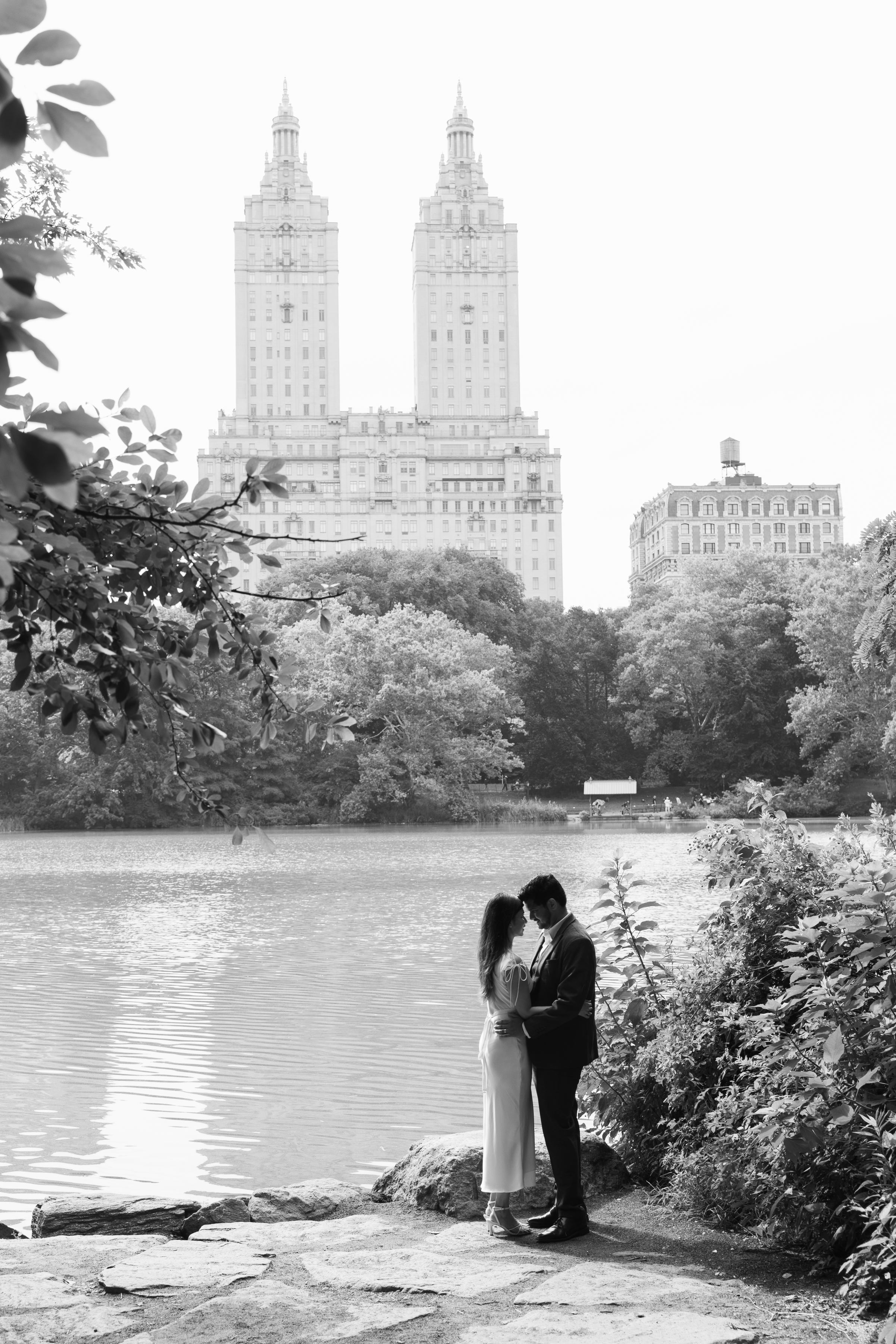 A couple embracing beside the Central Park lake beneath the San Remo towers, in black and white