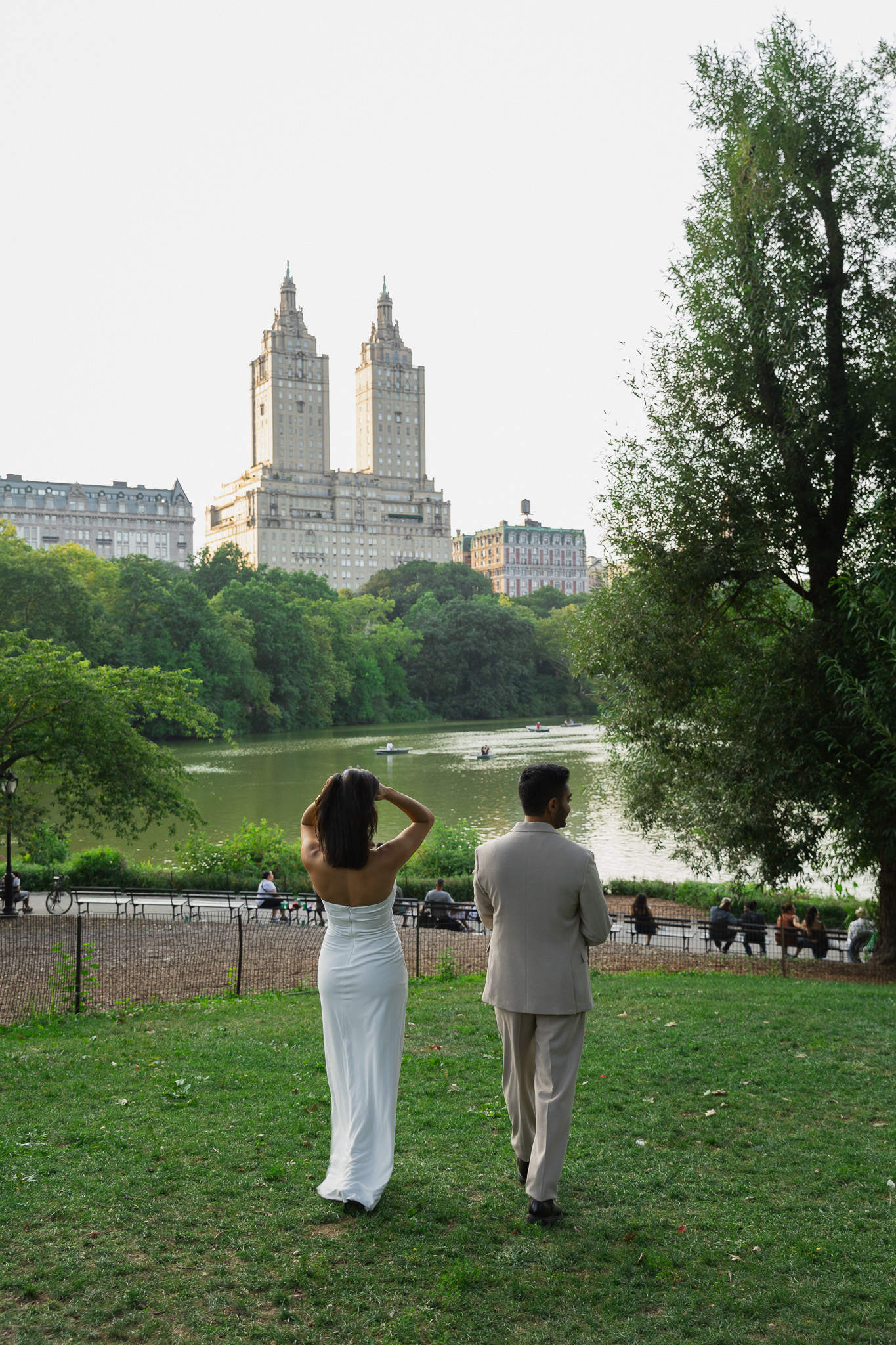 Open lawn in Central Park looking toward the Upper West Side, with the towers of the San Remo rising above the treeline