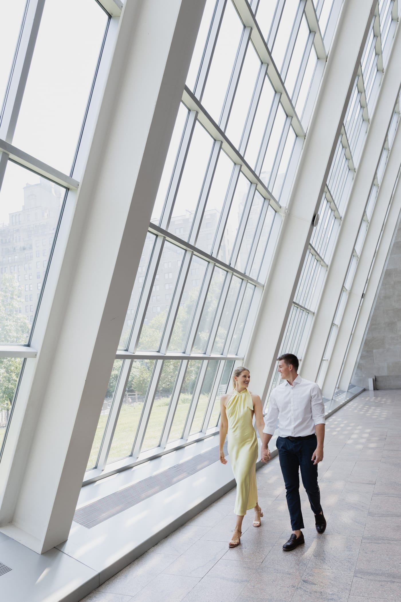 Couple walking beside the tall glass wall at the Metropolitan Museum of Art, New York