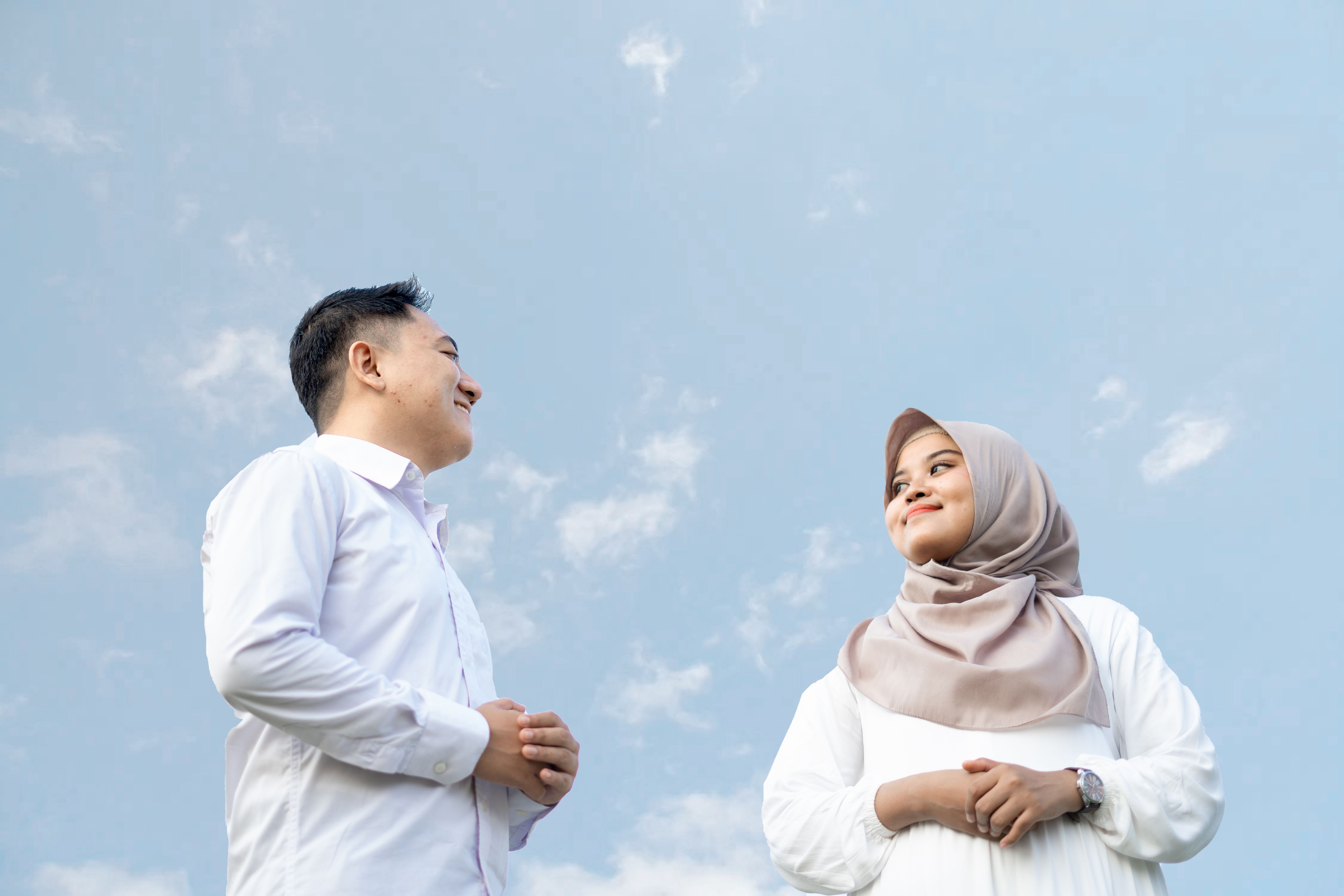 Muslim couple in different countries speaking through a video call while families participate in a long-distance marriage process.