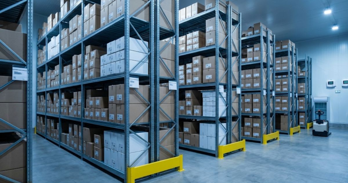 Cartons de médicaments empilés dans un entrepôt pharmaceutique, ambiance sobre