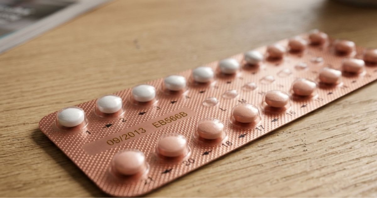 Plaquette de pilules contraceptives posée sur un comptoir de pharmacie, ambiance sobre