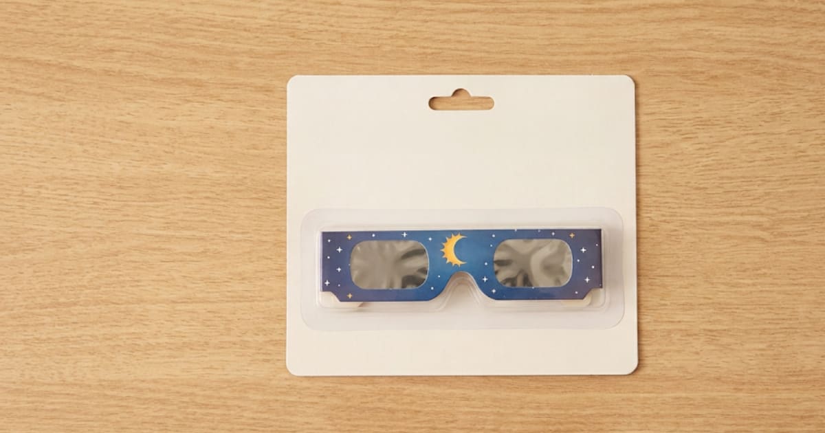 Lunettes de protection solaire posées sur un comptoir de pharmacie, ambiance sobre et professionnelle