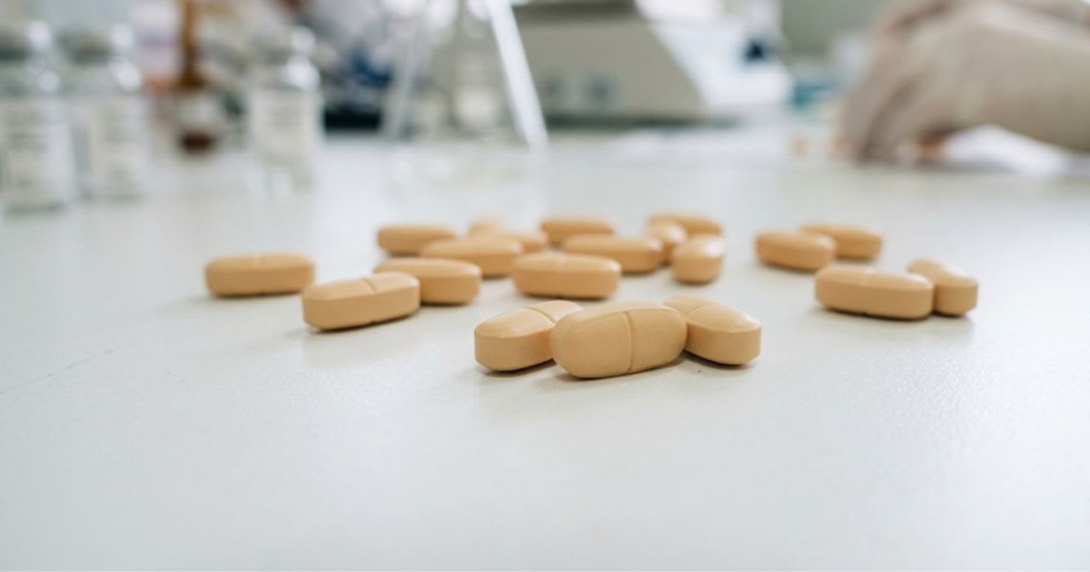 Comprimés pelliculés à libération prolongée sur surface blanche de laboratoire